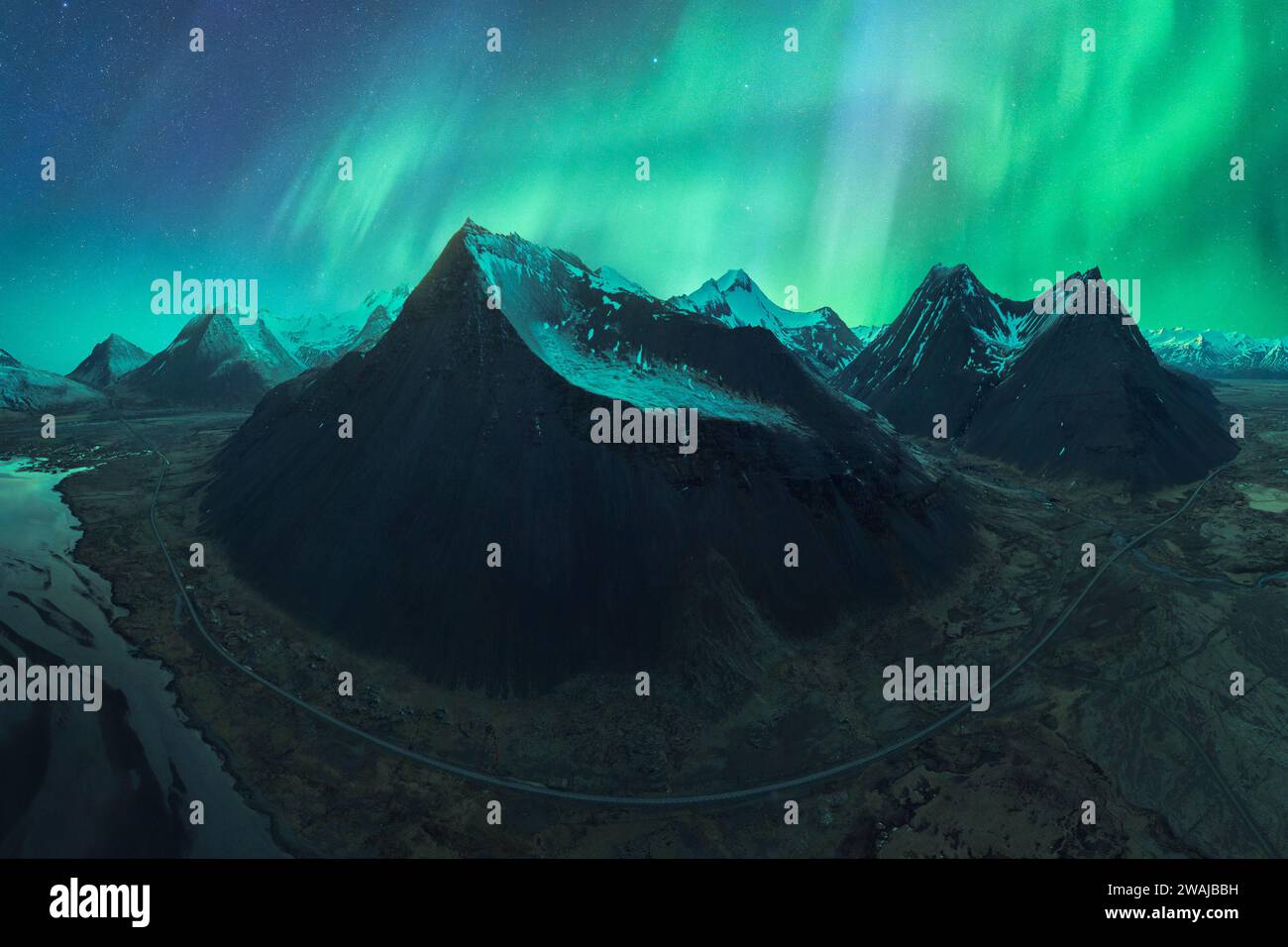 Northern Lights illuminating the sky above a black sand beach in Vik ...