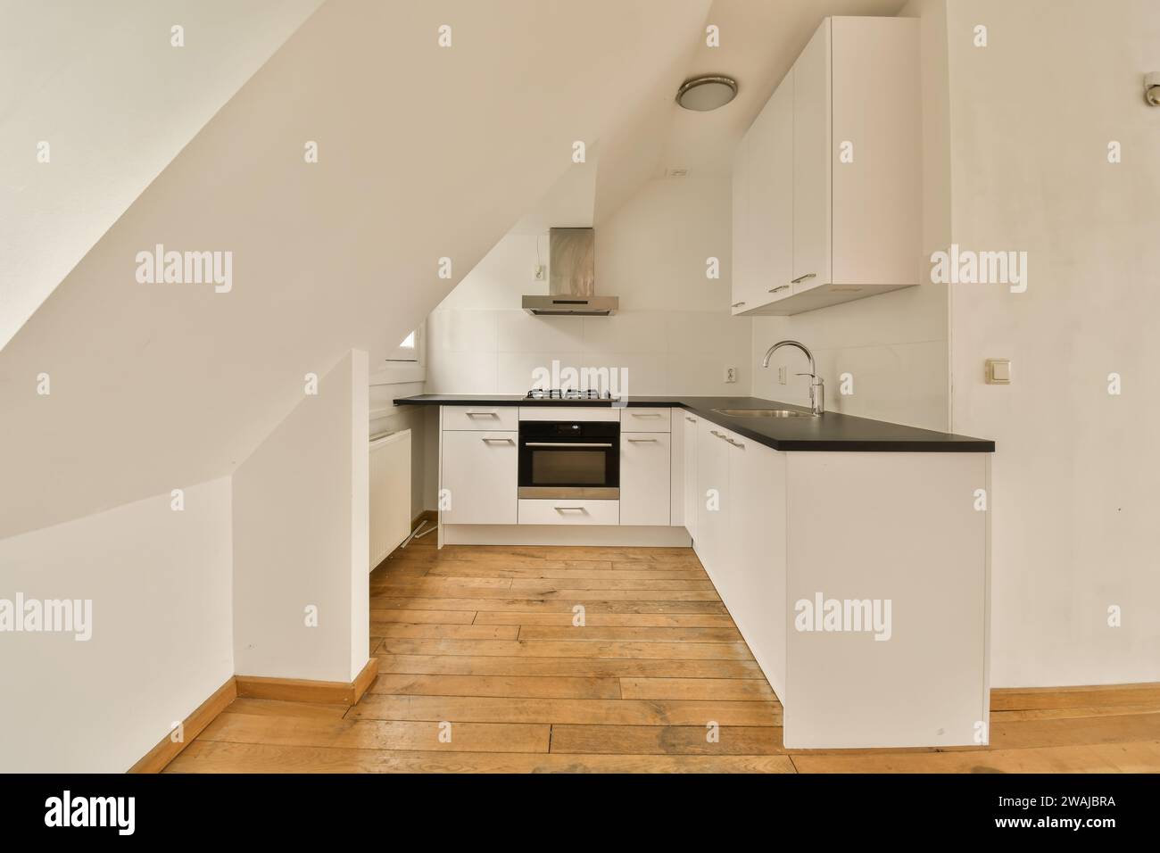 Interior of modern refurbished kitchen with white cabinets and black ...