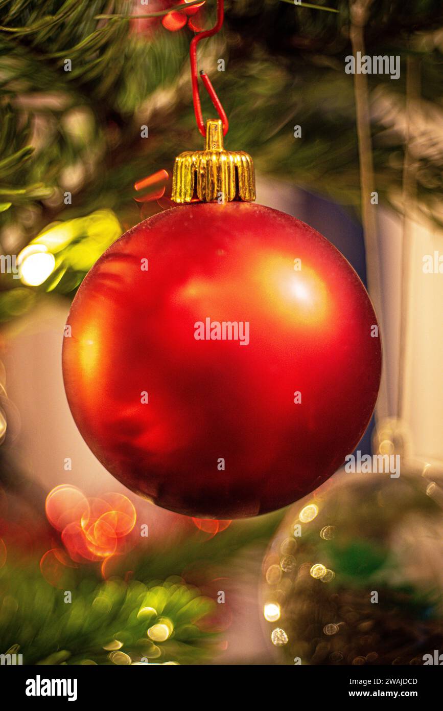A festive red Christmas ornament with illuminated lights in the background, creating a warm atmosphere Stock Photo
