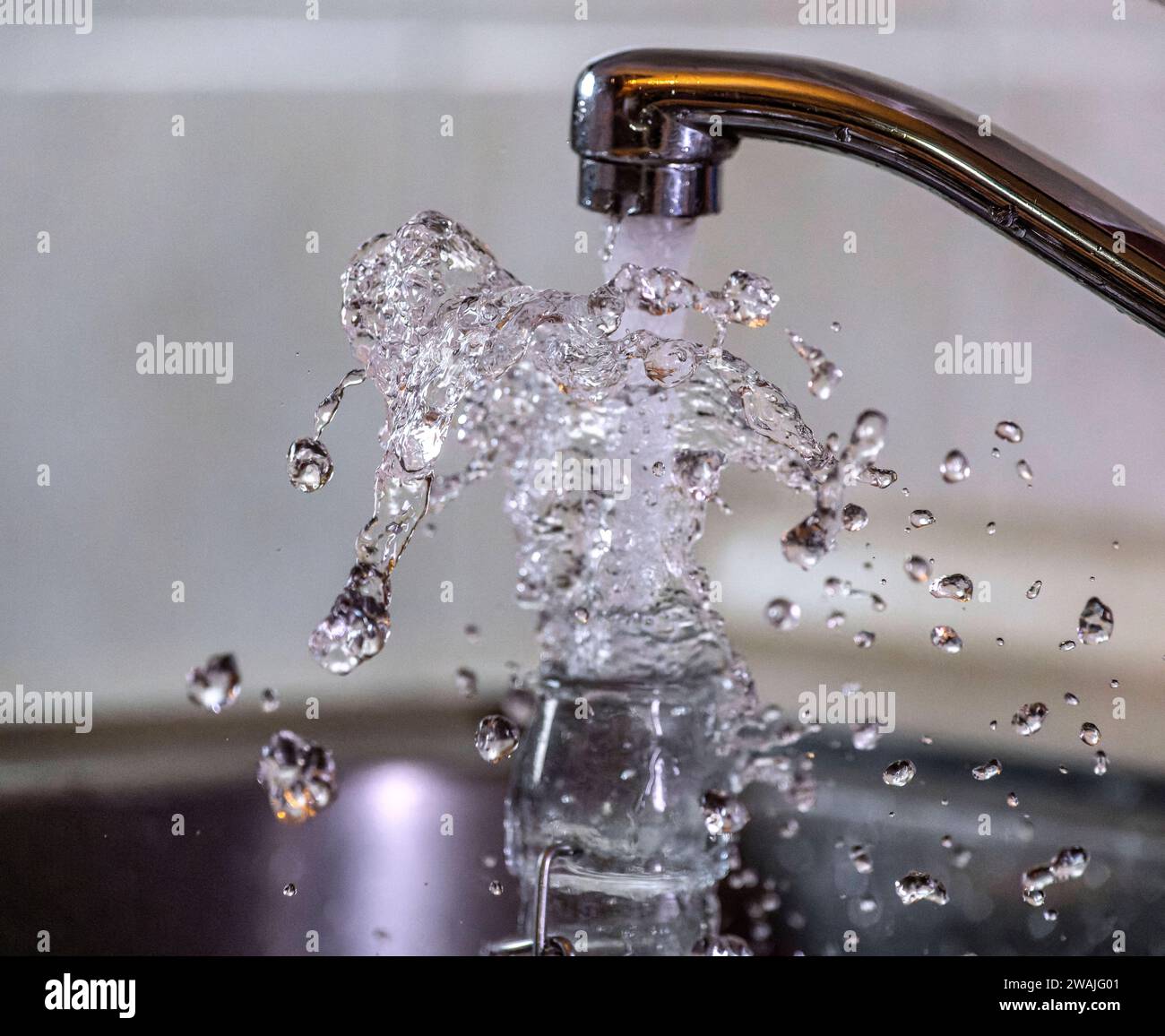 03.01.2024, Wasser spritzt aus dem Wasserhahn in einer Küche in Bad Wörishofen Bayern. 03.01.2024, Wasser aus dem Wasserhahn 03.01.2024, Wasser aus dem Wasserhahn *** 03 01 2024, Water spraying from the tap in a kitchen in Bad Wörishofen Bavaria 03 01 2024, Water from the tap 03 01 2024, Water from the tap Stock Photo