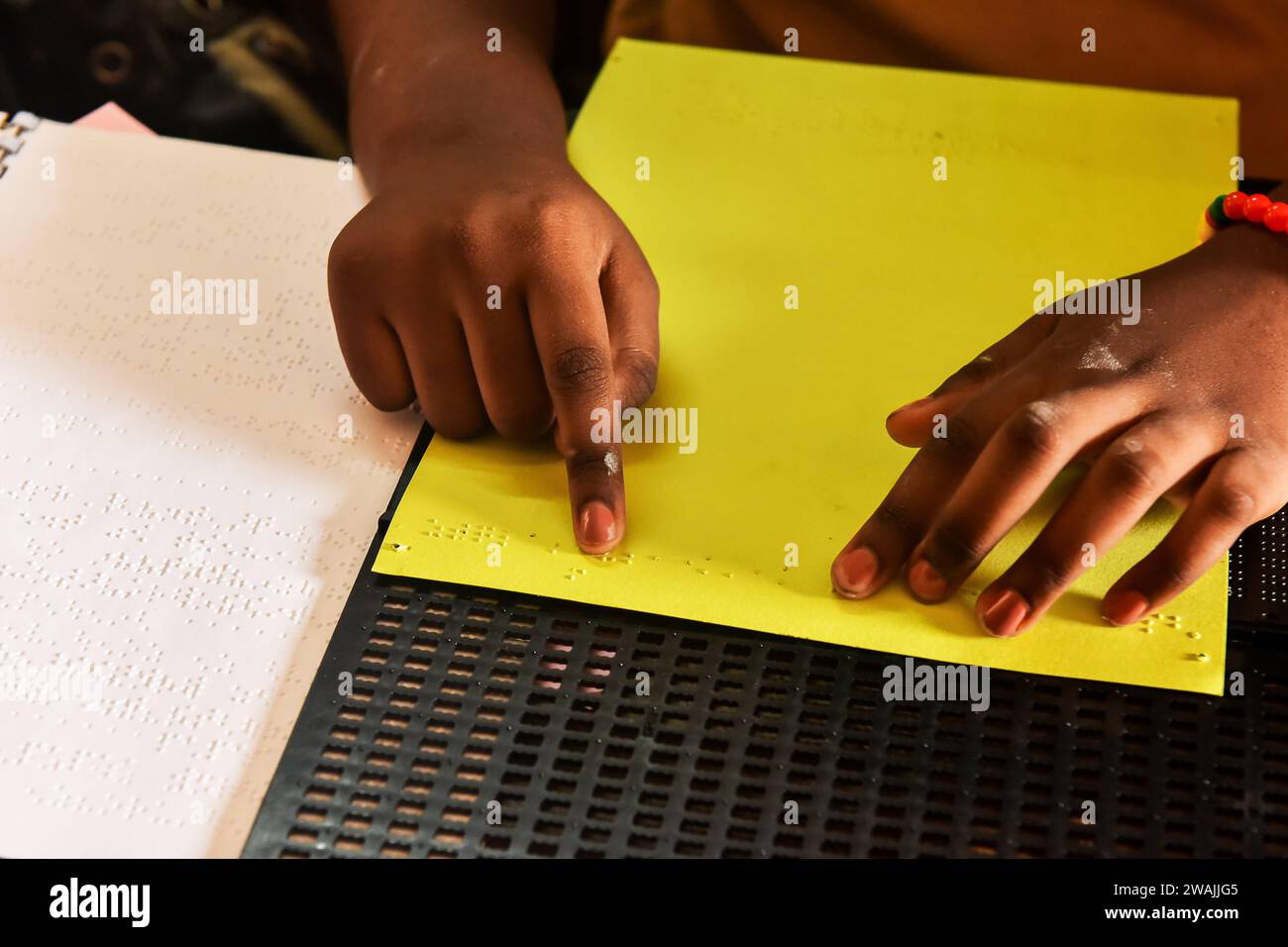 Yaounde, Cameroon. 4th Jan, 2024. A student copies a text with Braille ...