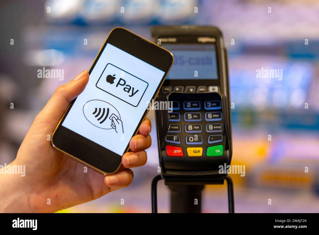 03.01.2024, Frau bezahlt mit Smartphone mittels hinterlegter Kredit-Karte im Geschäft. Symbolbild 03.01.2024, Kartenzahlung 03.01.2024, Kartenzahlung *** 03 01 2024, Woman pays with smartphone using deposited credit card in store Symbolic image 03 01 2024, Card payment 03 01 2024, Card payment Stock Photo