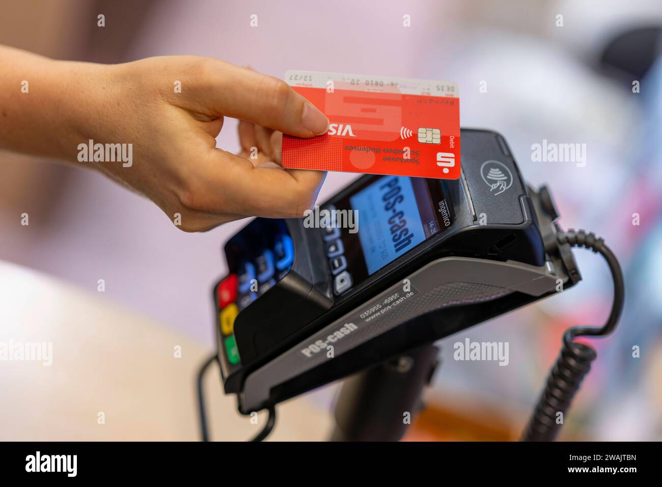 03.01.2024, Frau bezahlt mit der EC-Karte im Geschäft. Kontaktloses Bezahlen mit dem NFC-Chip 