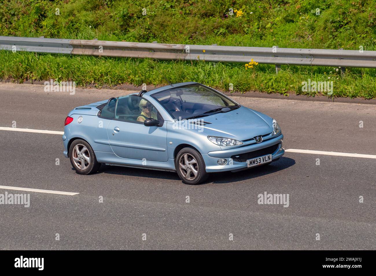 2004 Silver Blue Peugeot 206 Allure Car Convertible Petrol 1587 cc; travelling at speed on the M6 motorway in Greater Manchester, UK Stock Photo