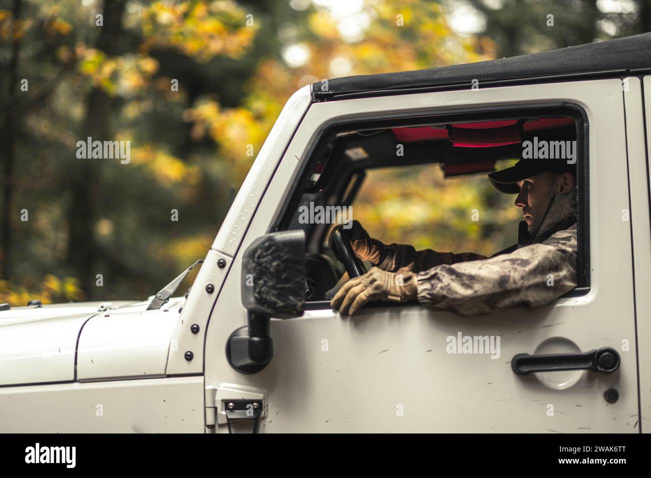 Camouflage Wearing Caucasian Hunter In His Sport Utility Vehicle. Hunting Season Theme. Stock Photo