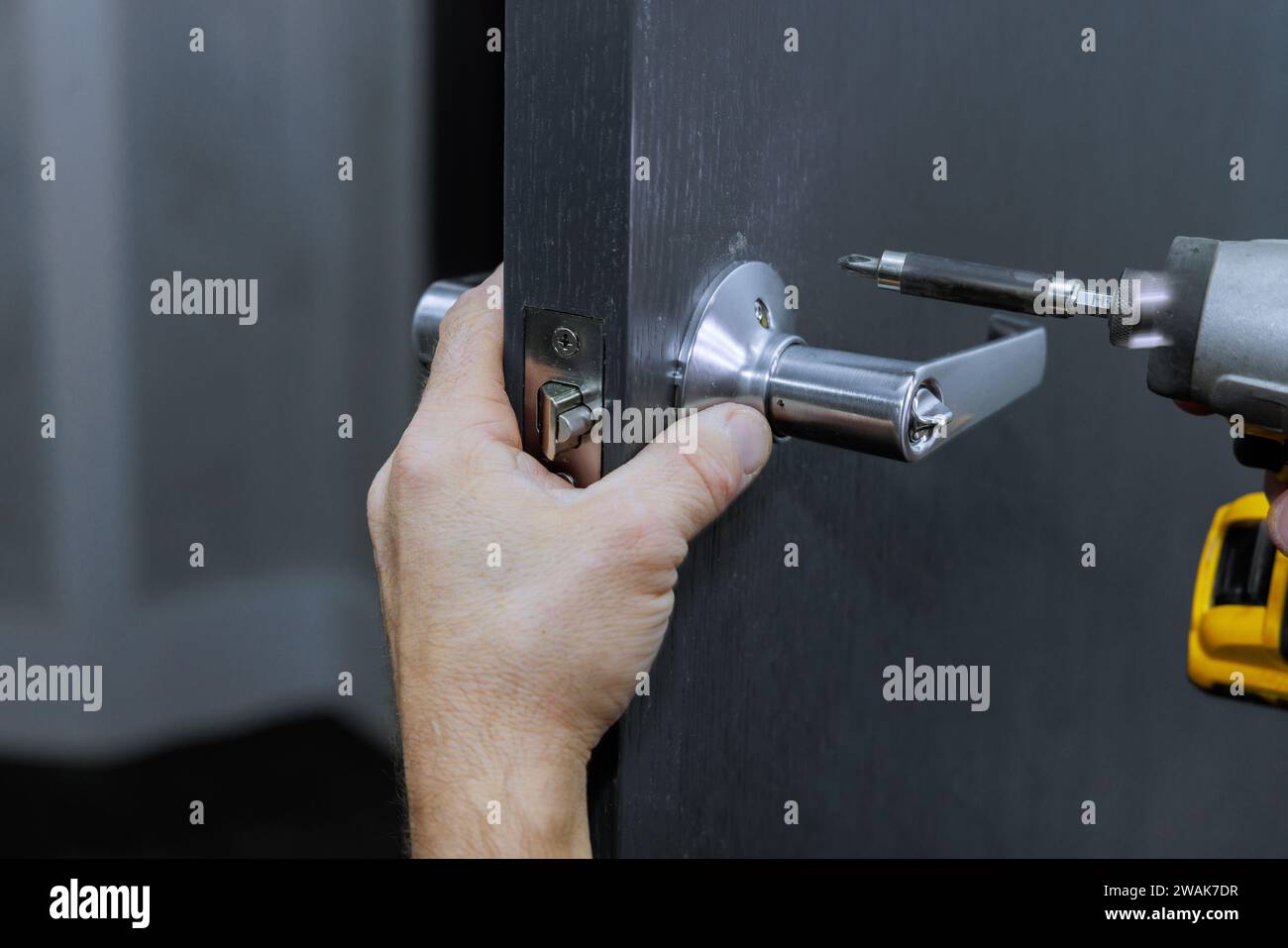 Screwdriver Lock Worker installs lock in hi-res stock photography and images - Alamy