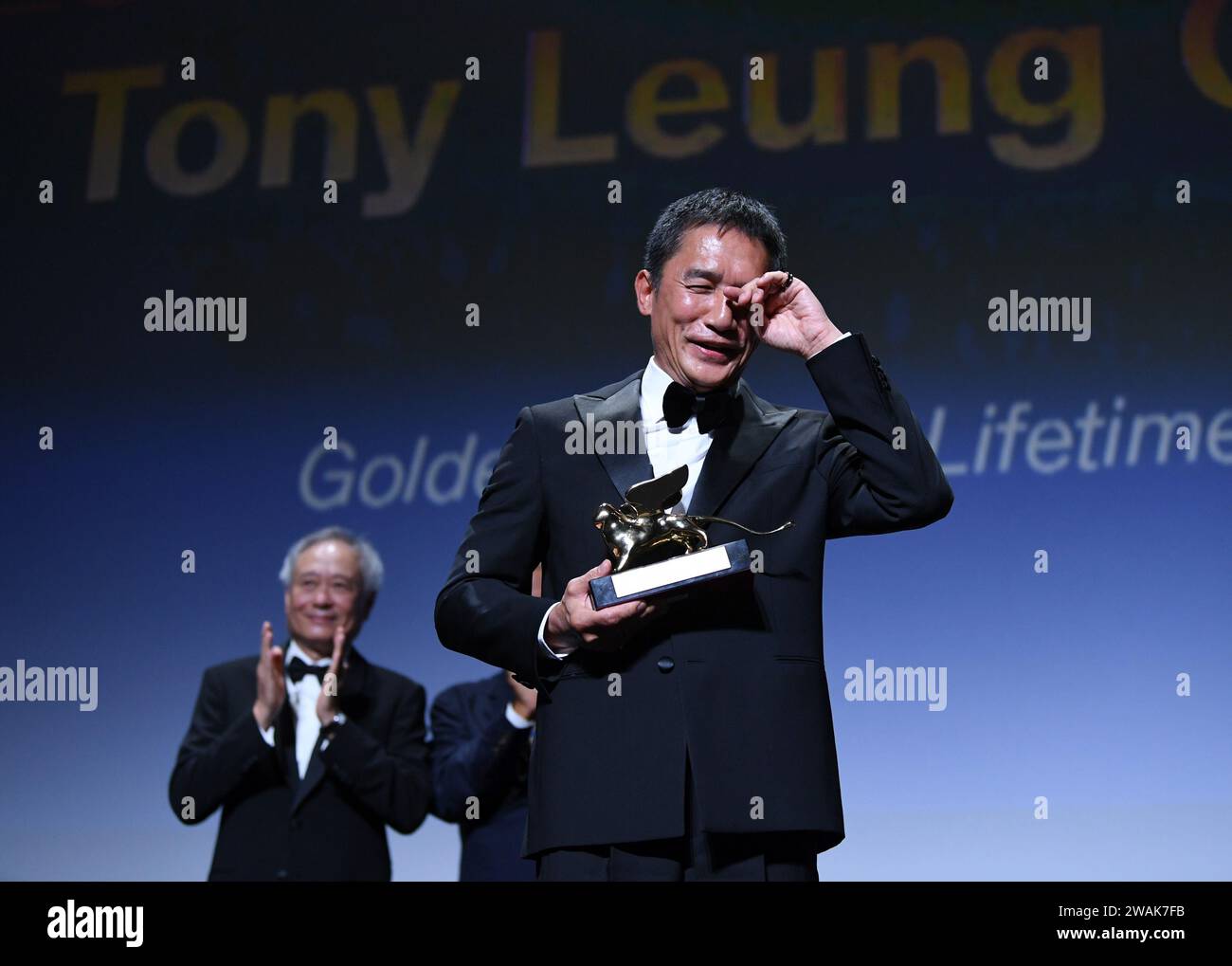 Beijing, Italy. 2nd Sep, 2023. Actor Tony Leung Chiu-Wai of Hong Kong, China wipes his tears when he is awarded the Golden Lion for Lifetime Achievement at an award ceremony during the 80th Venice International Film Festival in Venice, Italy, on Sept. 2, 2023. Credit: Jin Mamengni/Xinhua/Alamy Live News Stock Photo