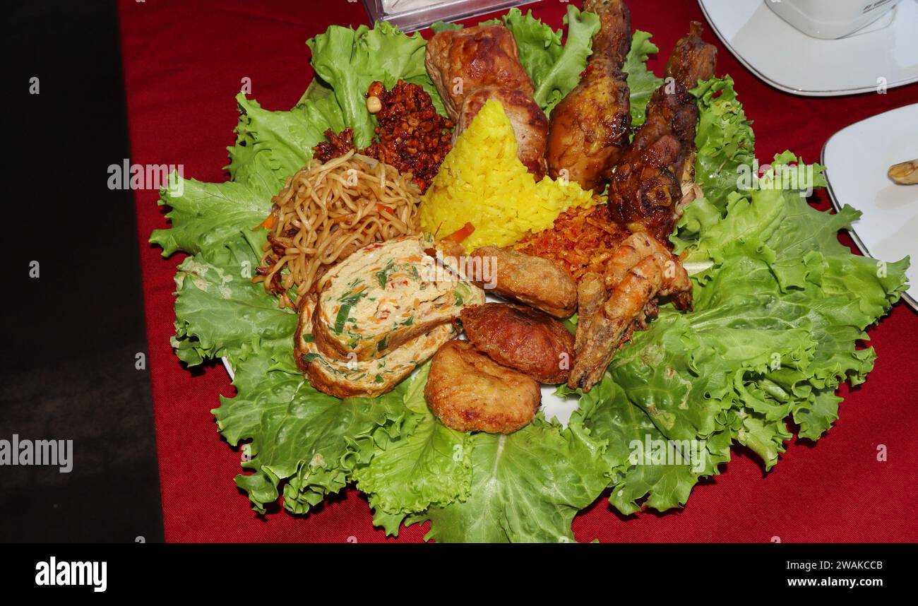 Rice in a cone shape or called Nasi Tumpeng A festive Indonesian rice dish with side dishes Stock Photo