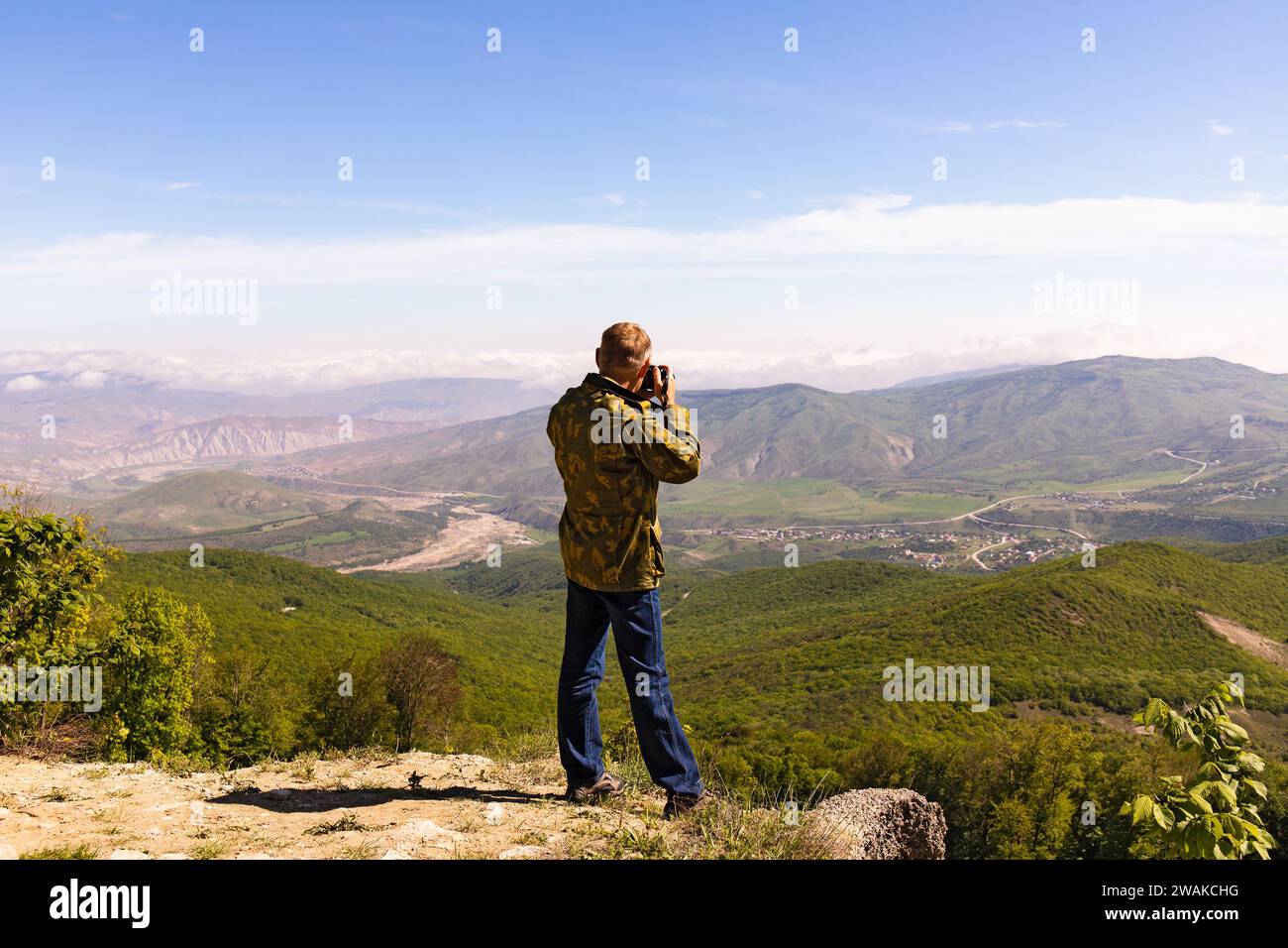 The photographer photographs a beautiful landscape from the mountain. Khyzy region. Azerbaijan. Stock Photo