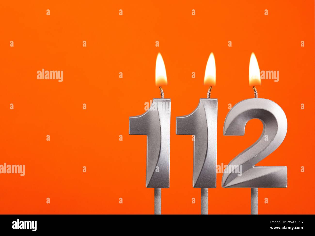 Candle number 112 - Birthday in orange background Stock Photo - Alamy