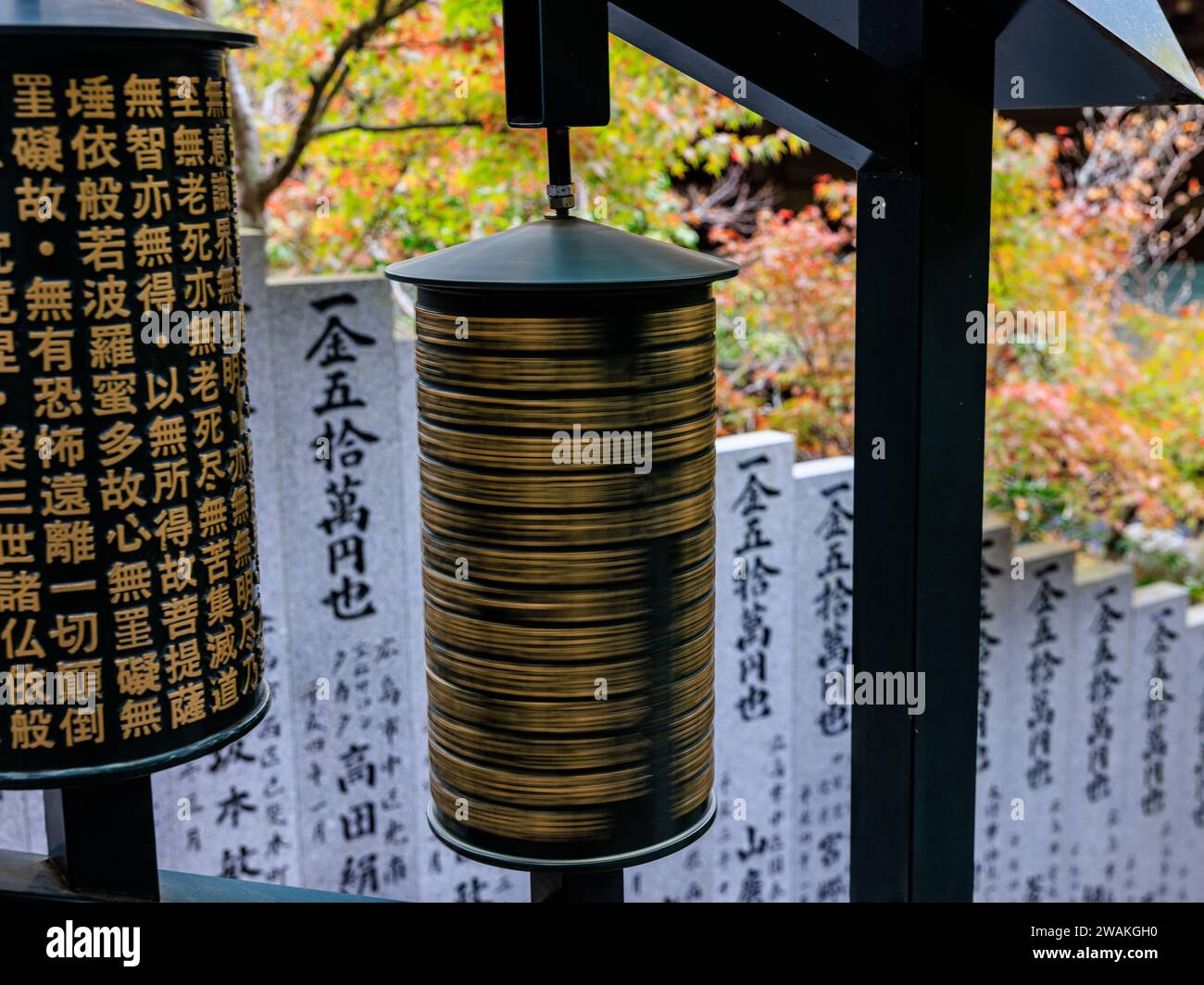 two large prayer wheels on the steps up to daisho-in temple one is spinning and one is stationary Stock Photo