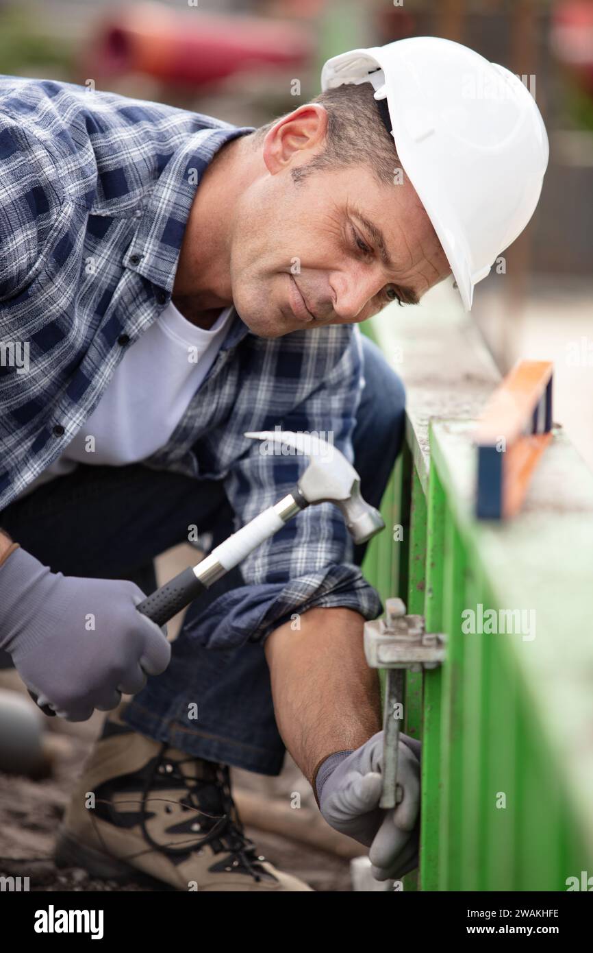 builder putting down a hammer on a building site Stock Photo
