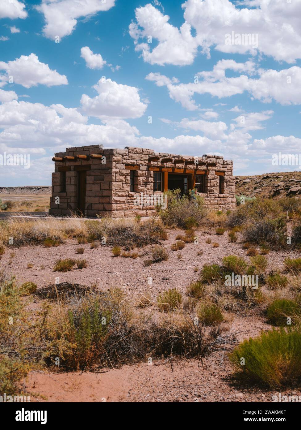 An antiquated stone house standing alone in the arid desert. Stock Photo