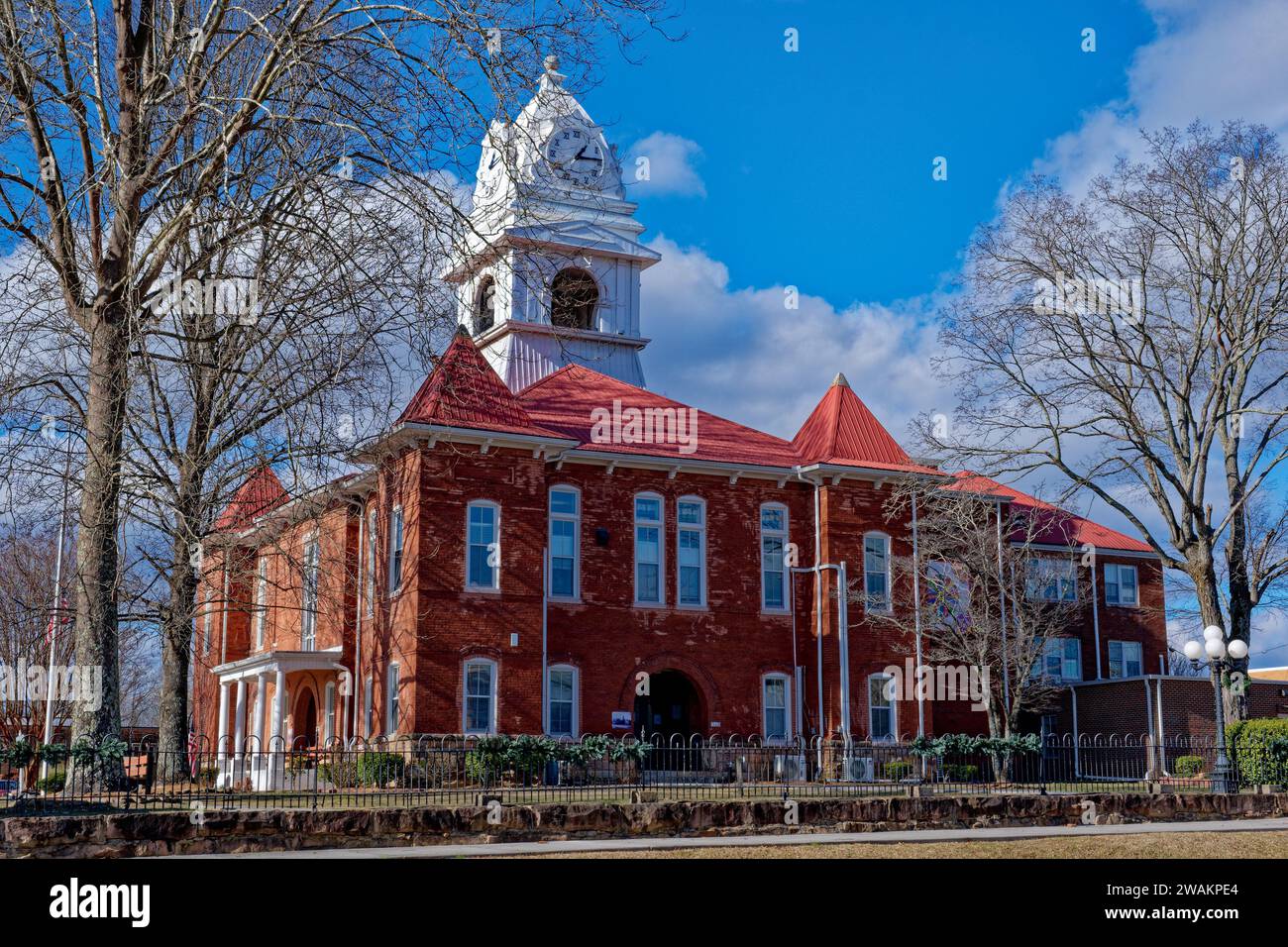 A restored historic building with a clock tower with a bell hanging inside the cupola in downtown Wartburg in the Tennessee mountains on a sunny day i Stock Photo