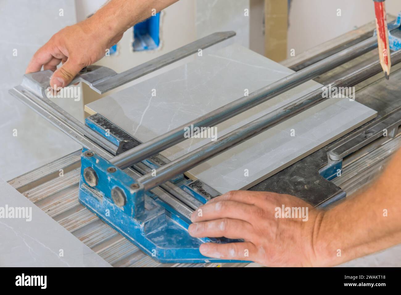 Ceramic tile is cut using hand operated tile cutting machine by ...