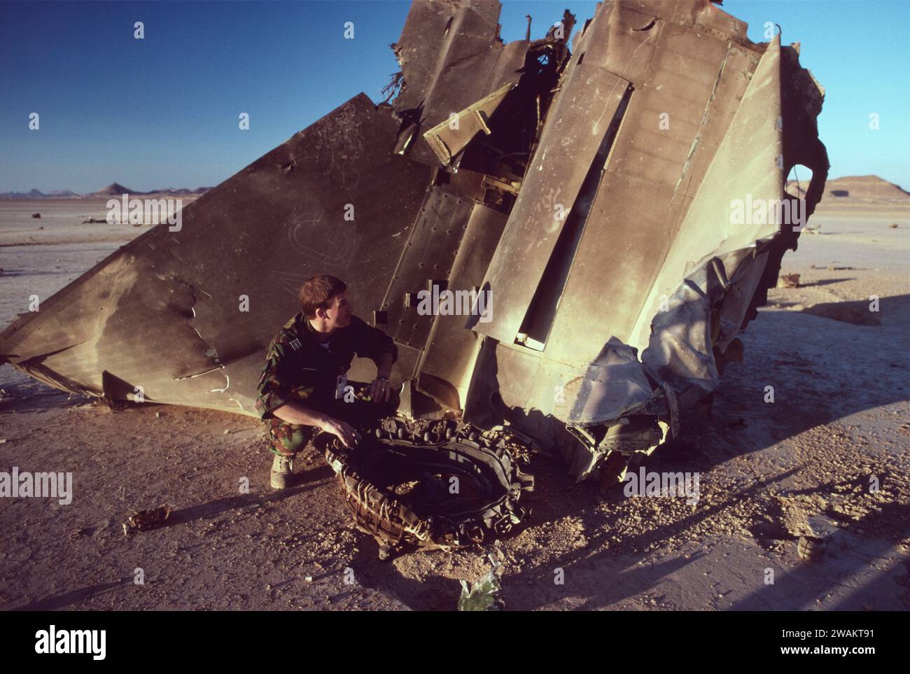 22nd Jan 1991 In the desert in north-west Saudi Arabia, a ground-crewman squats next to the wreckage of an RAF Tornado GR1. Stock Photo