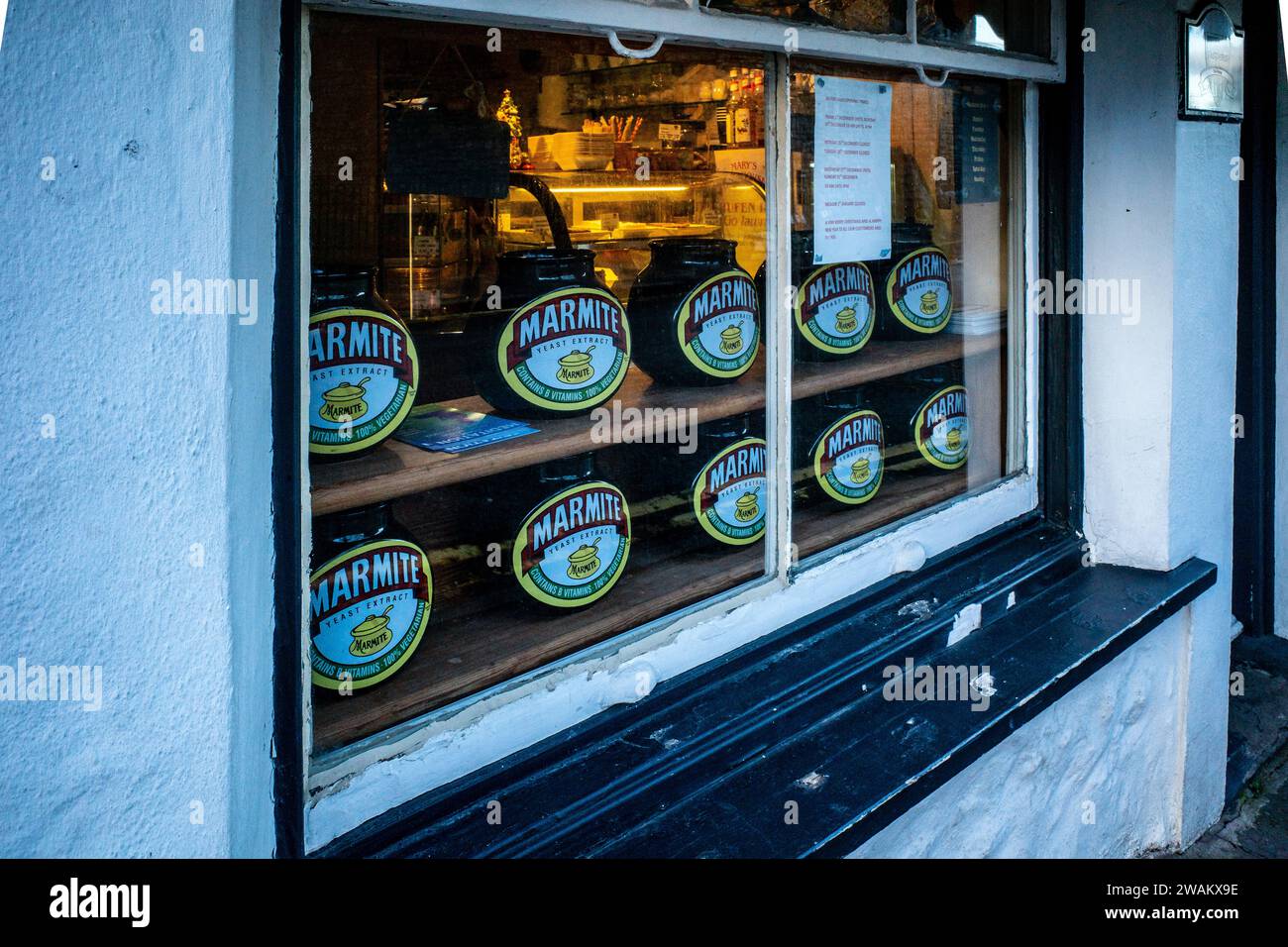 Marmite jar display in the window of a quaint village cafe in Llandaff Village, Wales on a Winter afternoon. Concept food and drink. Marmite. Stock Photo