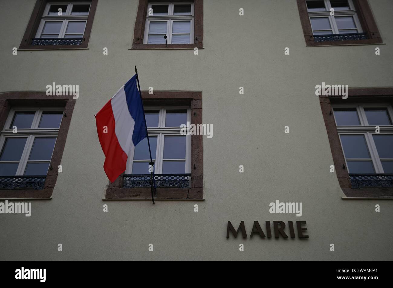 Scenic facade view of the Sélestat Town Hall with the waving French ...