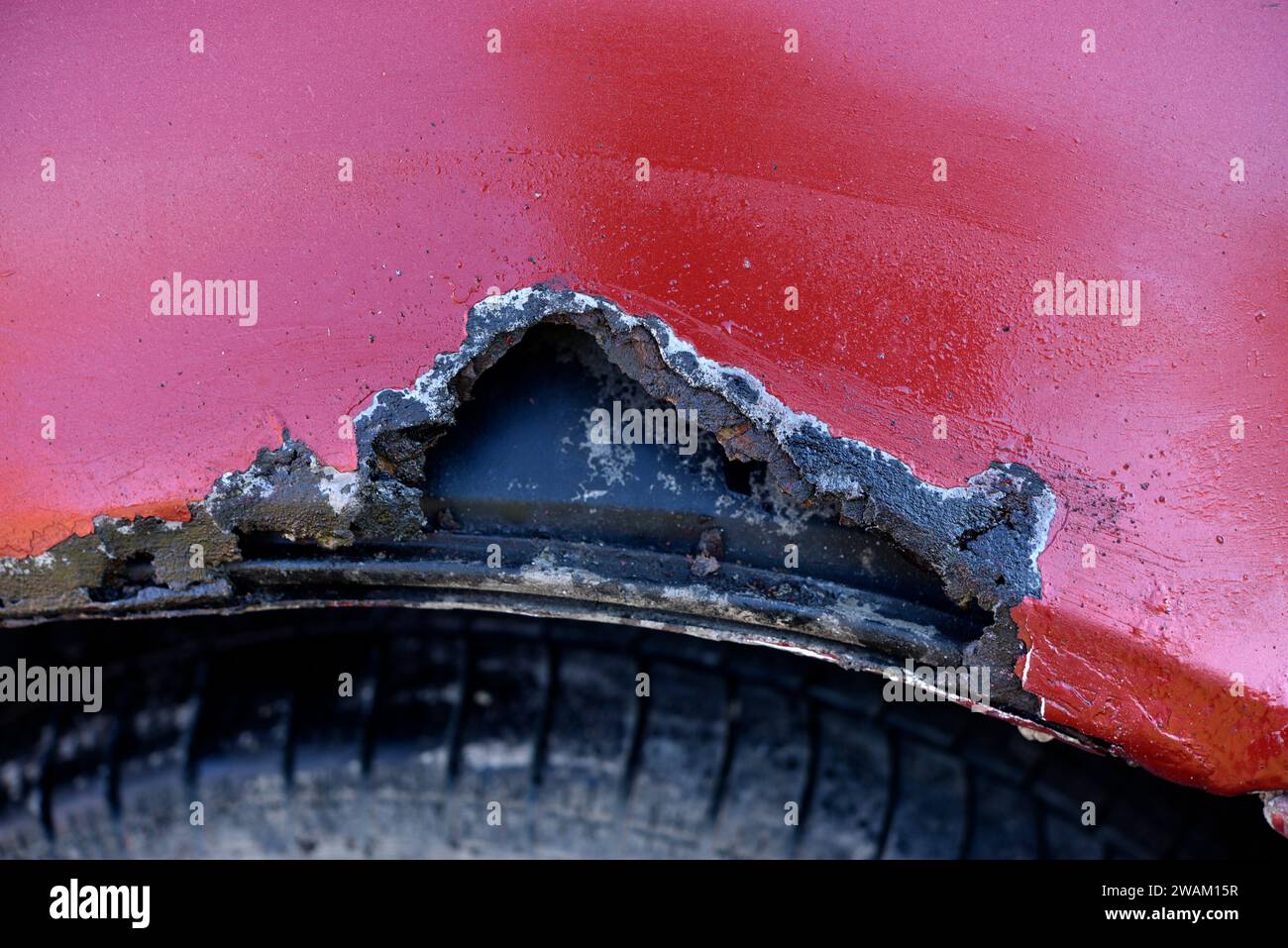 A rotten car. A rotten hole in the car body. A rotten car wing. Stock Photo