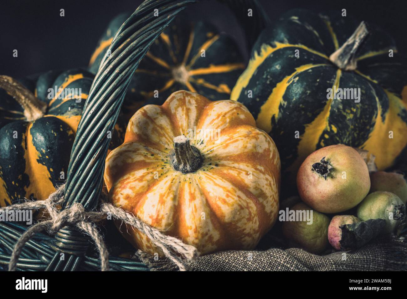 Various small pumpkins with a striped pattern in a basket, close-up Stock Photo