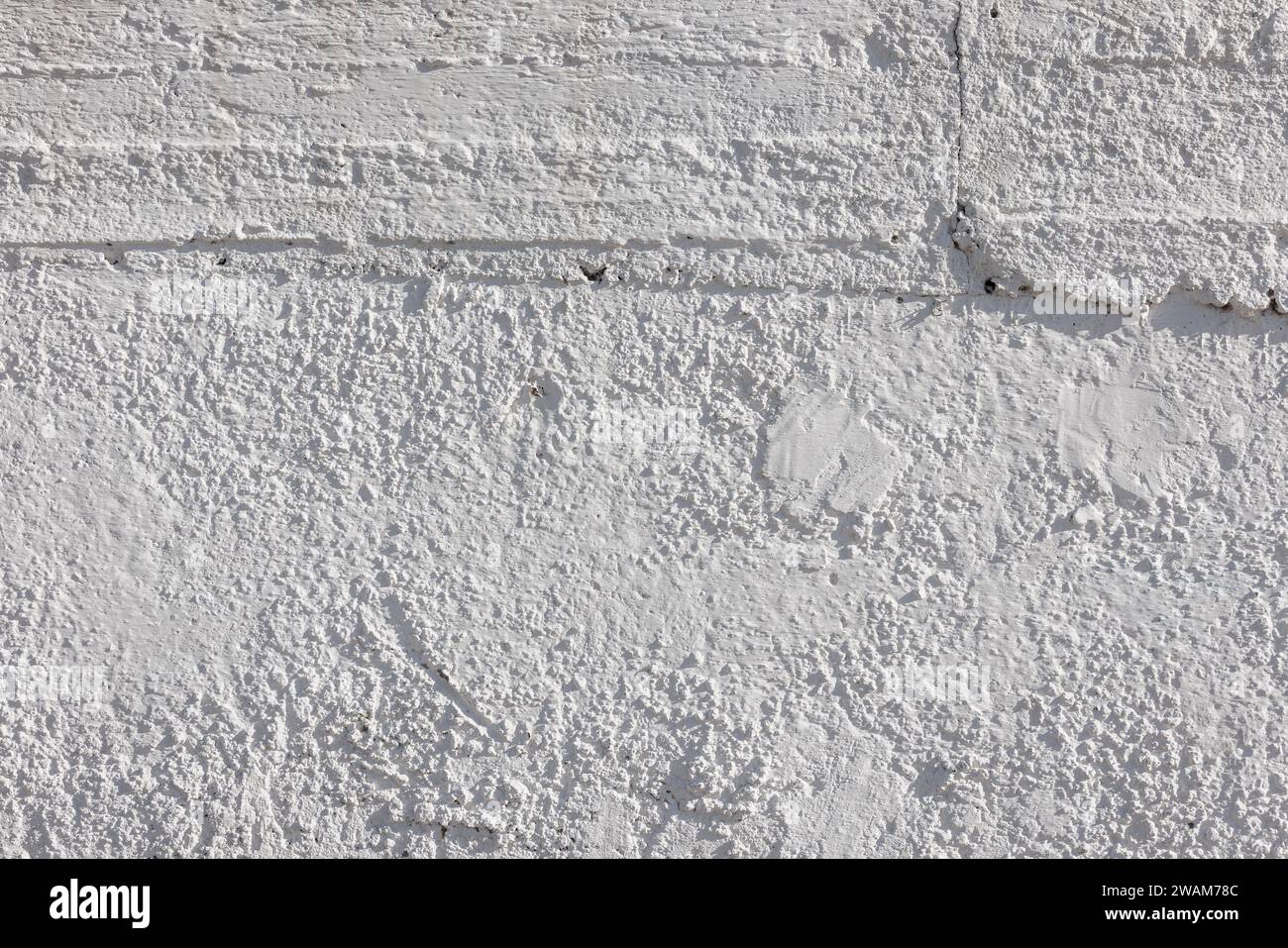 rough whitewash or white plaster wall under direct sunlight, full-frame background and texture Stock Photo