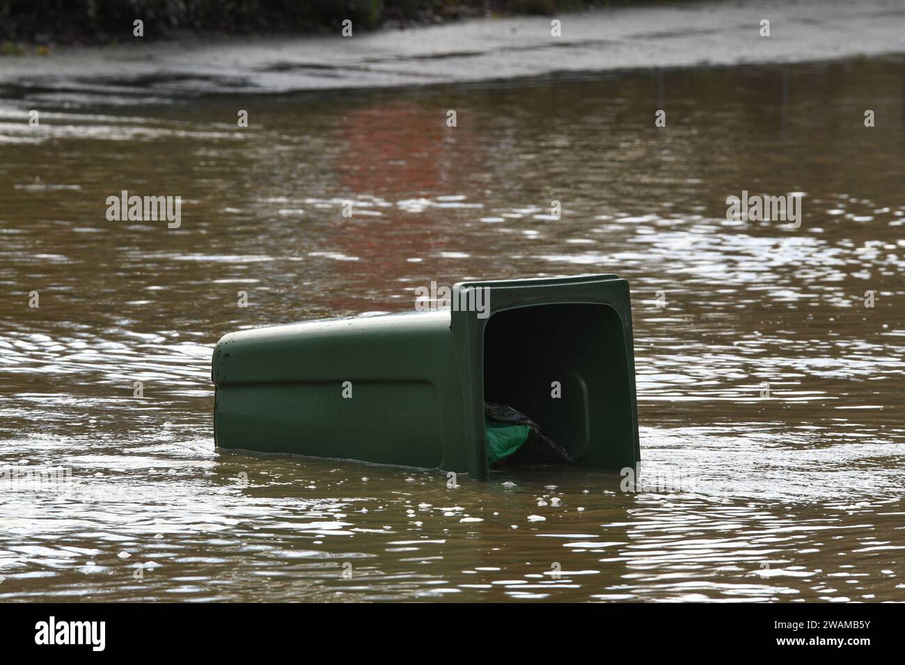 green wheelie bin floating in floodwater after storm henk Stock Photo
