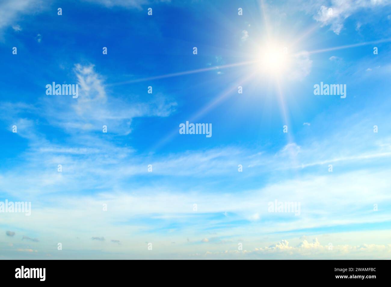 Couds in the blue sky. Bright midday sun illuminates the space. Stock Photo