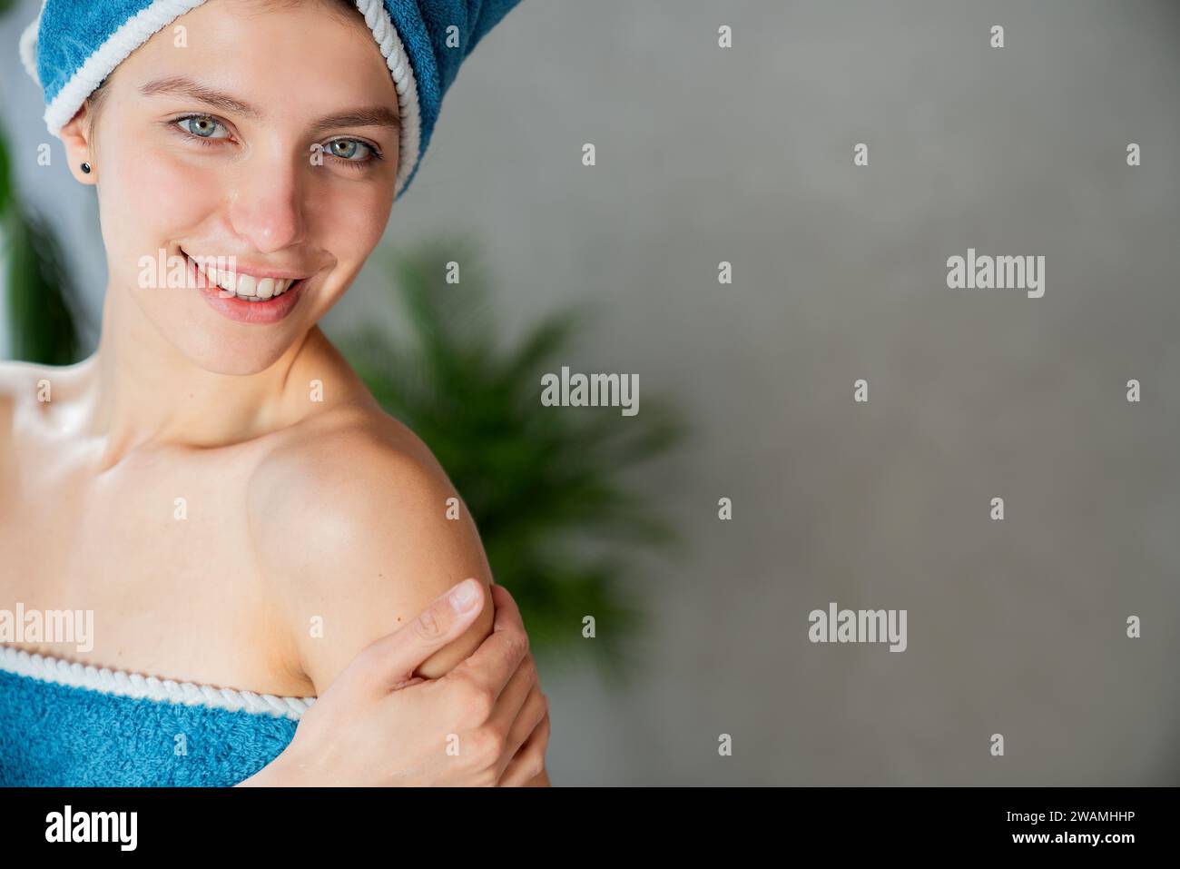 Woman with towel on head touching shoulder. Stock Photo