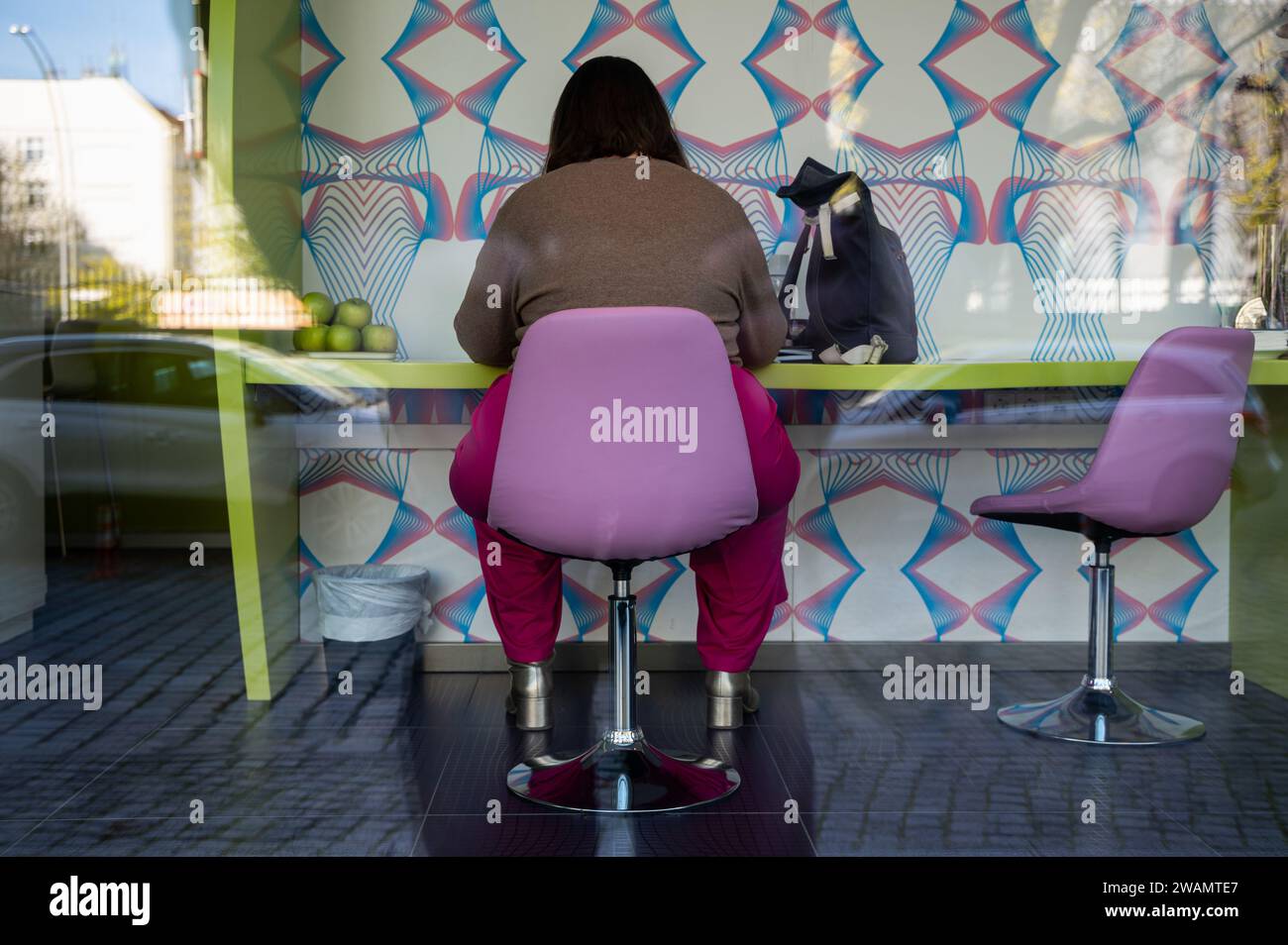 22.11.2023, Berlin, Germany, Europe - A woman sits on a swivel chair at a desk in the Hotel nhow Berlin in the locality of Friedrichshain. Stock Photo