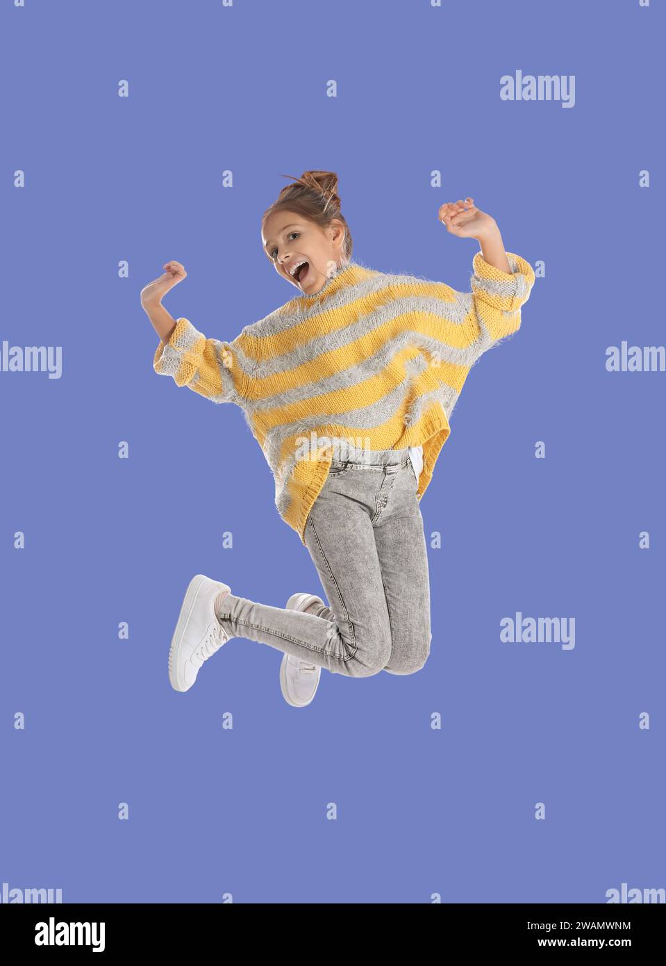 Happy cute girl jumping on light blue background Stock Photo - Alamy