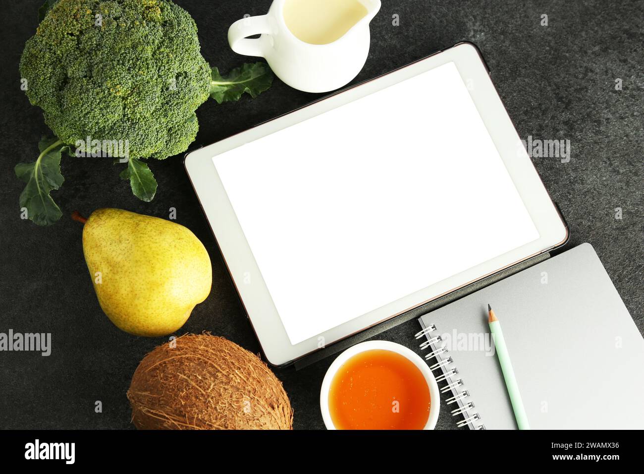 Glycemic index. Tablet with blank screen, different products and notebook on grey table, flat lay Stock Photo