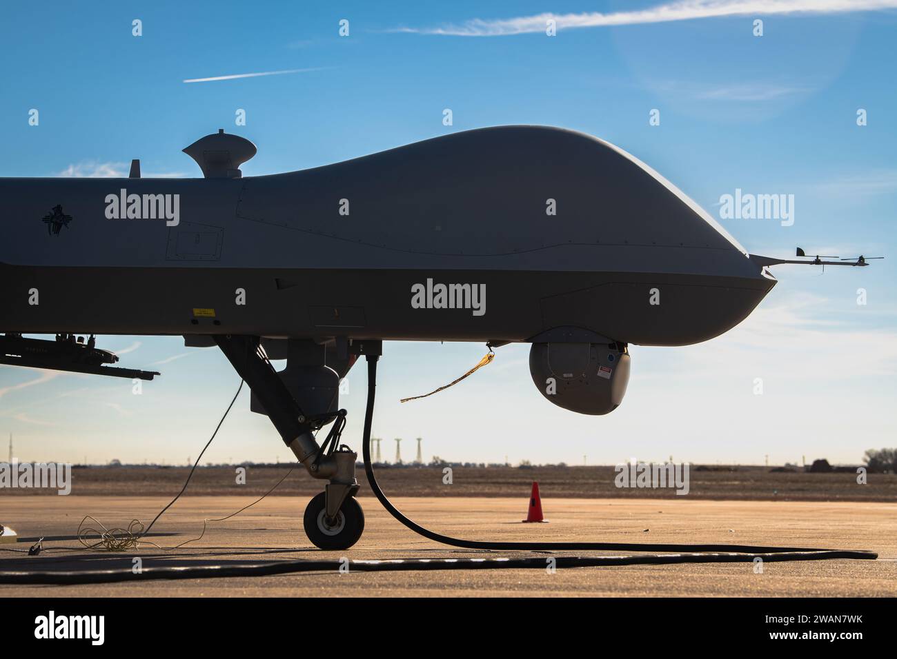 An MQ-9A Reaper remotely piloted aircraft operated by the 3rd Special Operations Squadron undergoes pre-flight checks before an experimental multi-aircraft control flight for the Adaptive Airborne Enterprise (A2E) at Cannon Air Force Base, N.M., Dec. 6, 2023. The flight marked the first attempt to simultaneously operate multiple remote aircraft from a single point of control. (U.S. Air Force photo by Staff Sgt. Vernon R. Walter III) (This photo has been edited for security purposes by blurring out aircraft information) Stock Photo