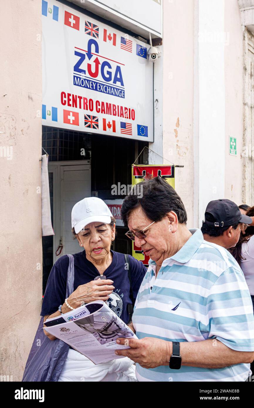 Merida Mexico,centro historico central historic district,money exchange,reading visitors information guide,man men male,woman women lady female,adults Stock Photo