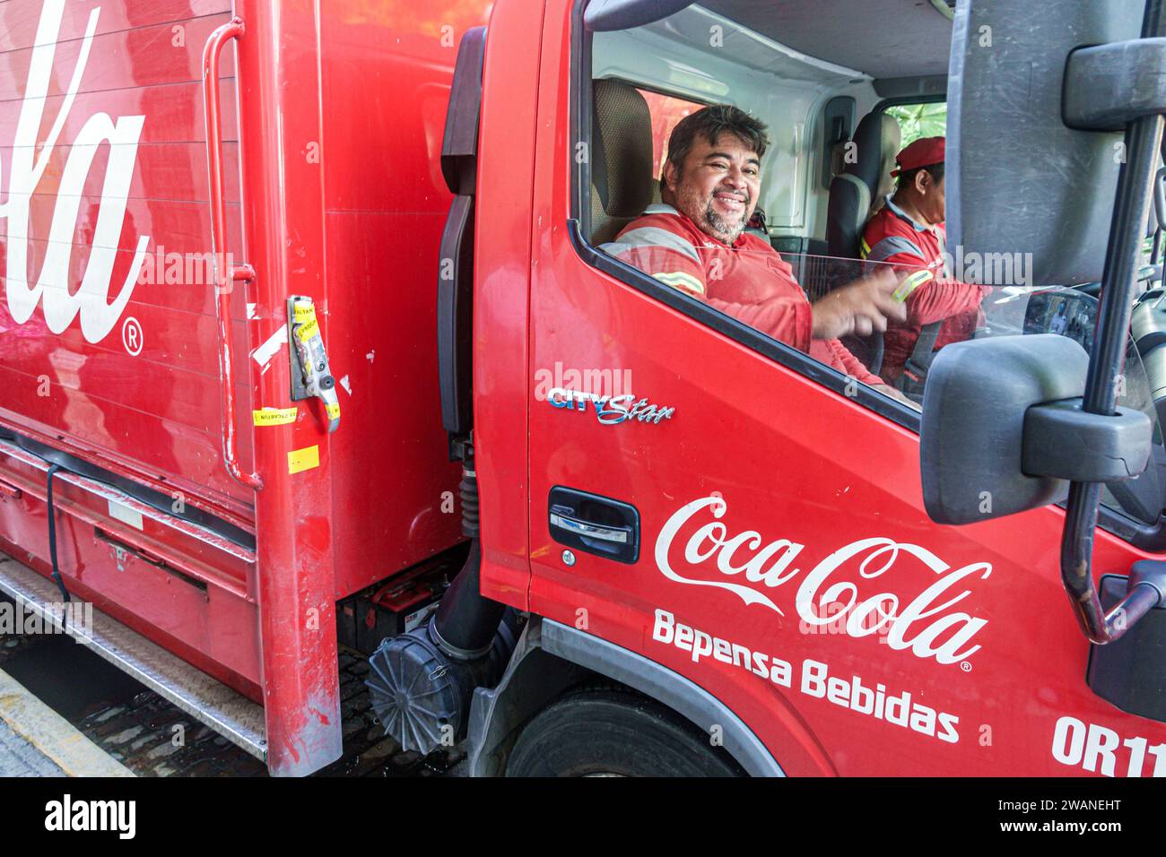 Merida Mexico,centro historico central historic district,Coca Cola delivery truck van,Bepensa Bebidas,man men male,adult,resident,driver deliveryman e Stock Photo