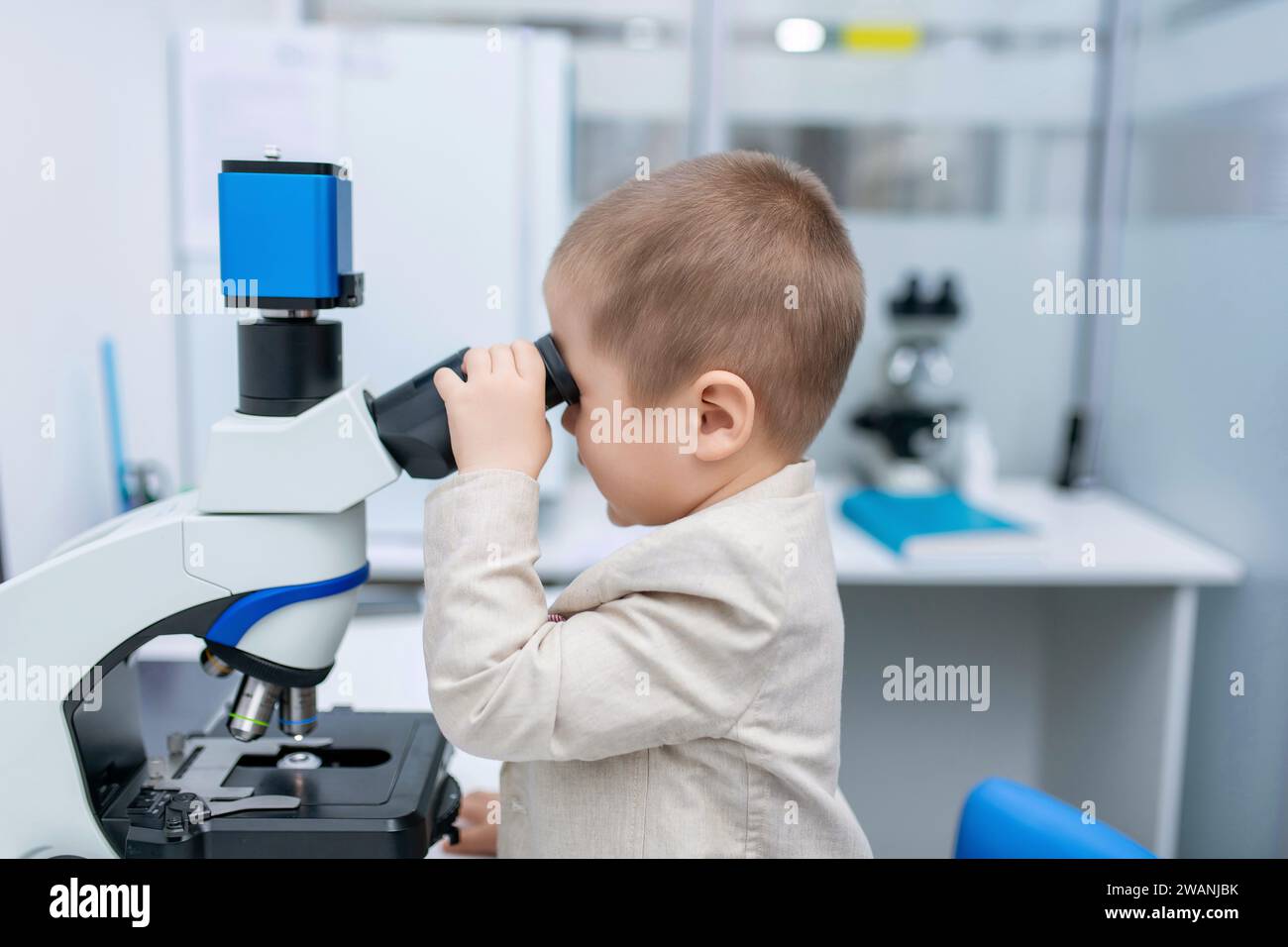 Little boy looking into microscope in the laboratory. Stock Photo