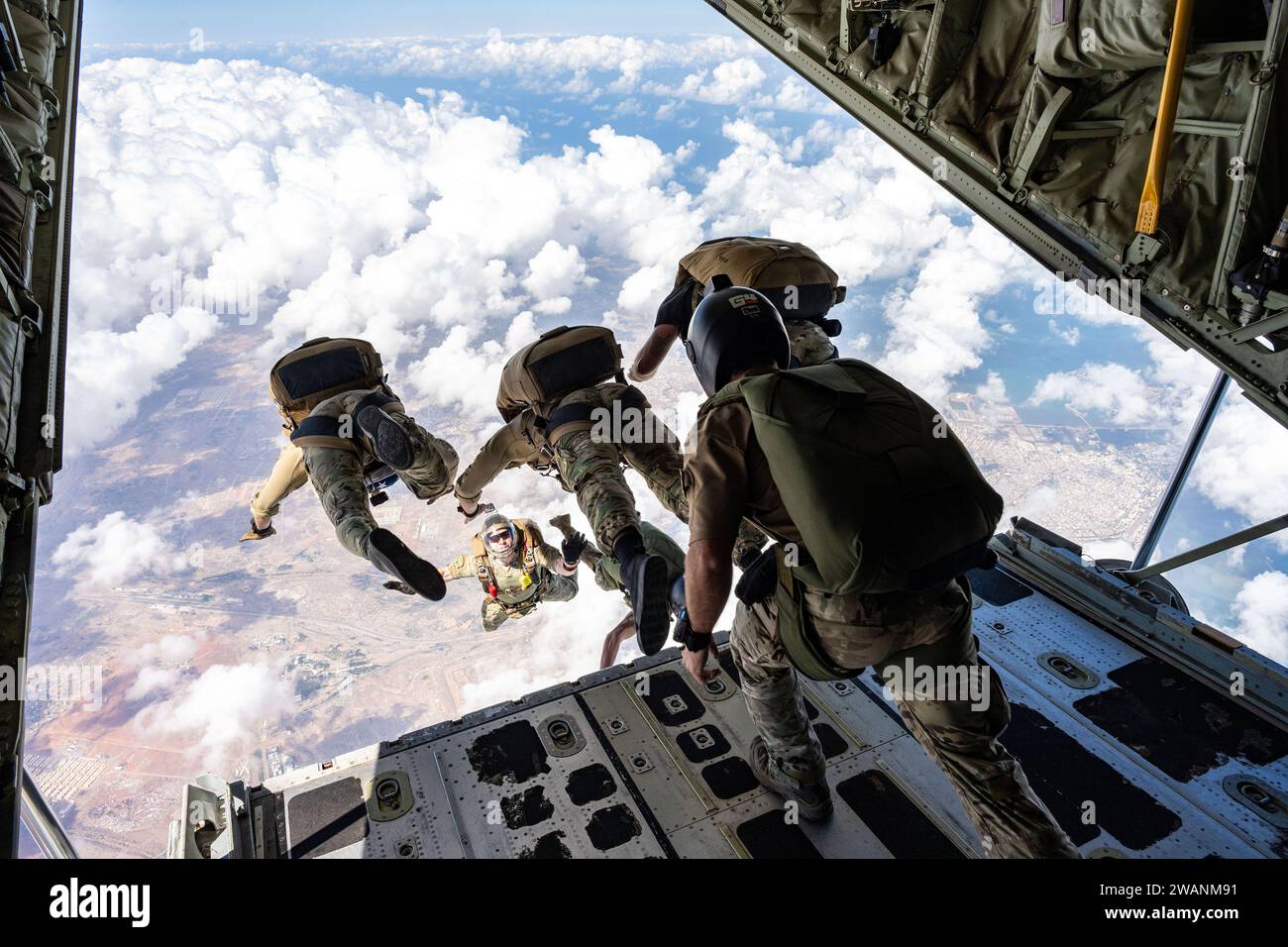 Djibouti. 27th Dec, 2023. U.S. Air Force operators assigned to the 82nd Expeditionary Rescue Squadron and Joint Personnel Recovery Center perform High Altitude, Low Opening (HALO) training jumps from a U.S. Marine Corps KC-130J Hercules cargo aircraft over East Africa, December. 27, 2023. HALO jumps are performed from altitudes where oxygen is limited, requiring members to employ specialized training beyond standard parachute insertions. (Credit Image: © Allison Payne/U.S. Air Force/ZUMA Press Wire) EDITORIAL USAGE ONLY! Not for Commercial USAGE! Stock Photo