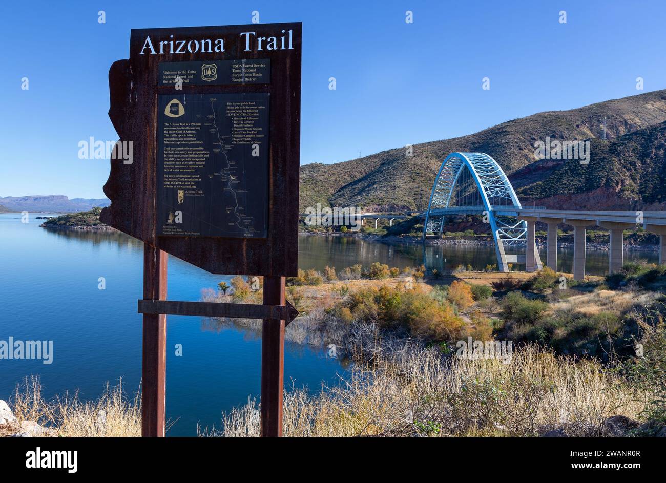 Arizona State Trail Board Sign and Map Rest Stop. Famous Roosevelt Lake Steel Bridge Scenic Landscape. Apache Trail Southwest US Landmark Blue Skyline Stock Photo