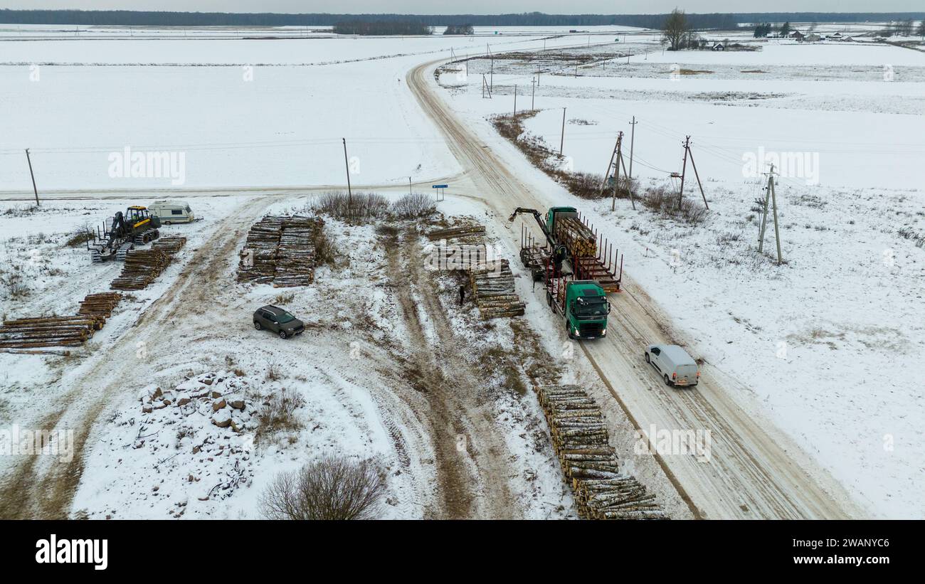 Drone photography of log lorry piking up logs during winter cloudy day Stock Photo