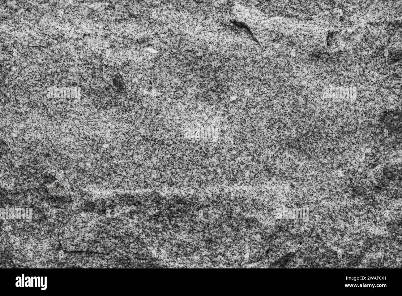 uneven wall surface. Dark gray granite stone background texture surface. Stock Photo