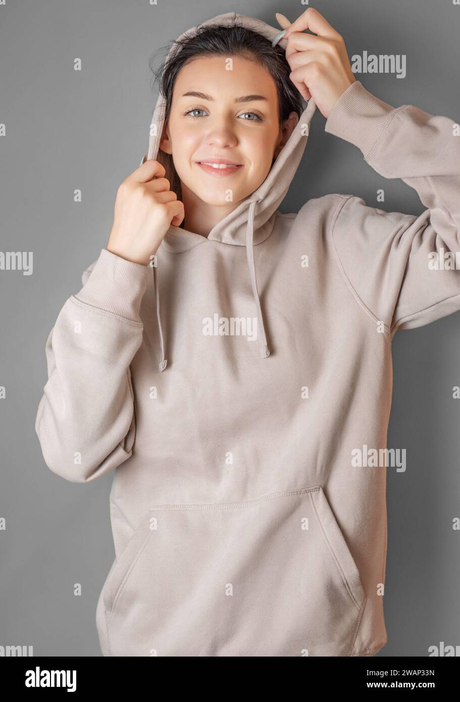 Portrait of a young pretty smoling girl in a  hoodie Stock Photo