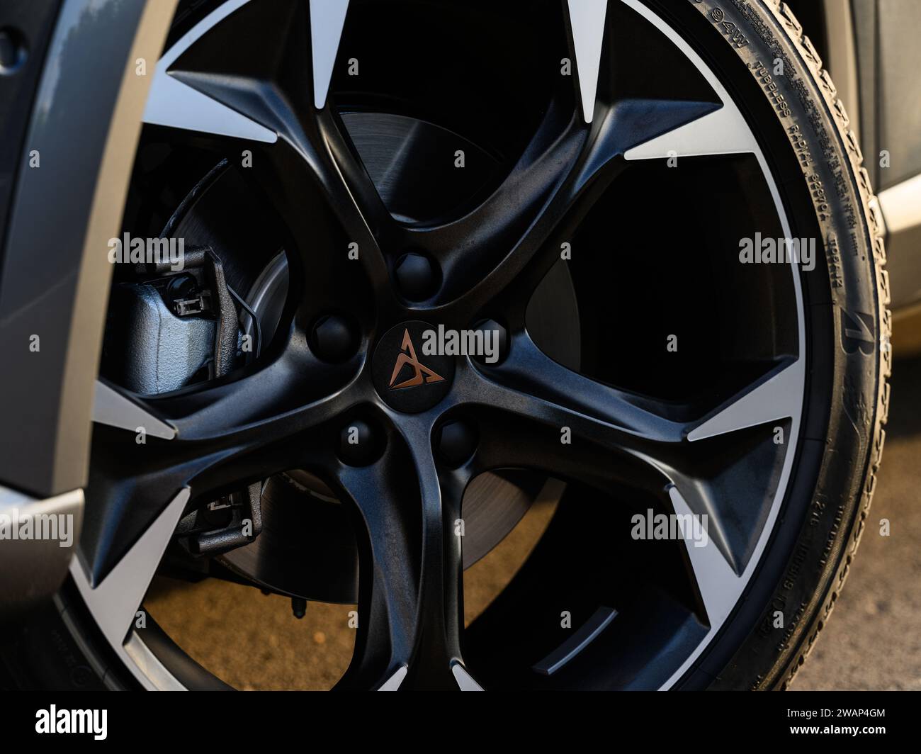 Detail of an aluminium and black rim with a Cupra car tyre with the ...