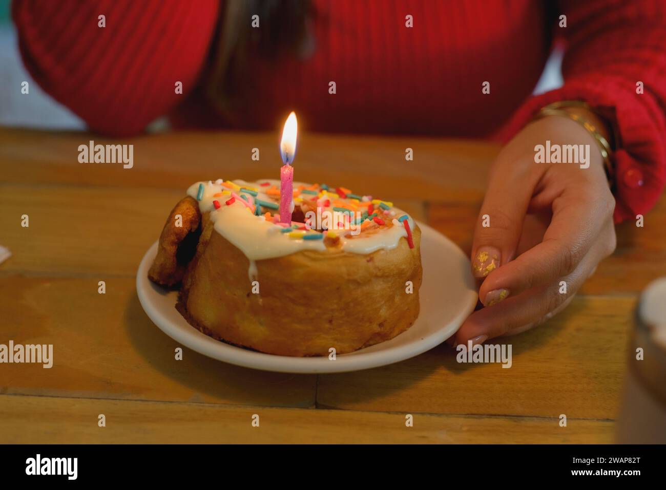 Woman hands holding dessert with birthday candle. Stock Photo