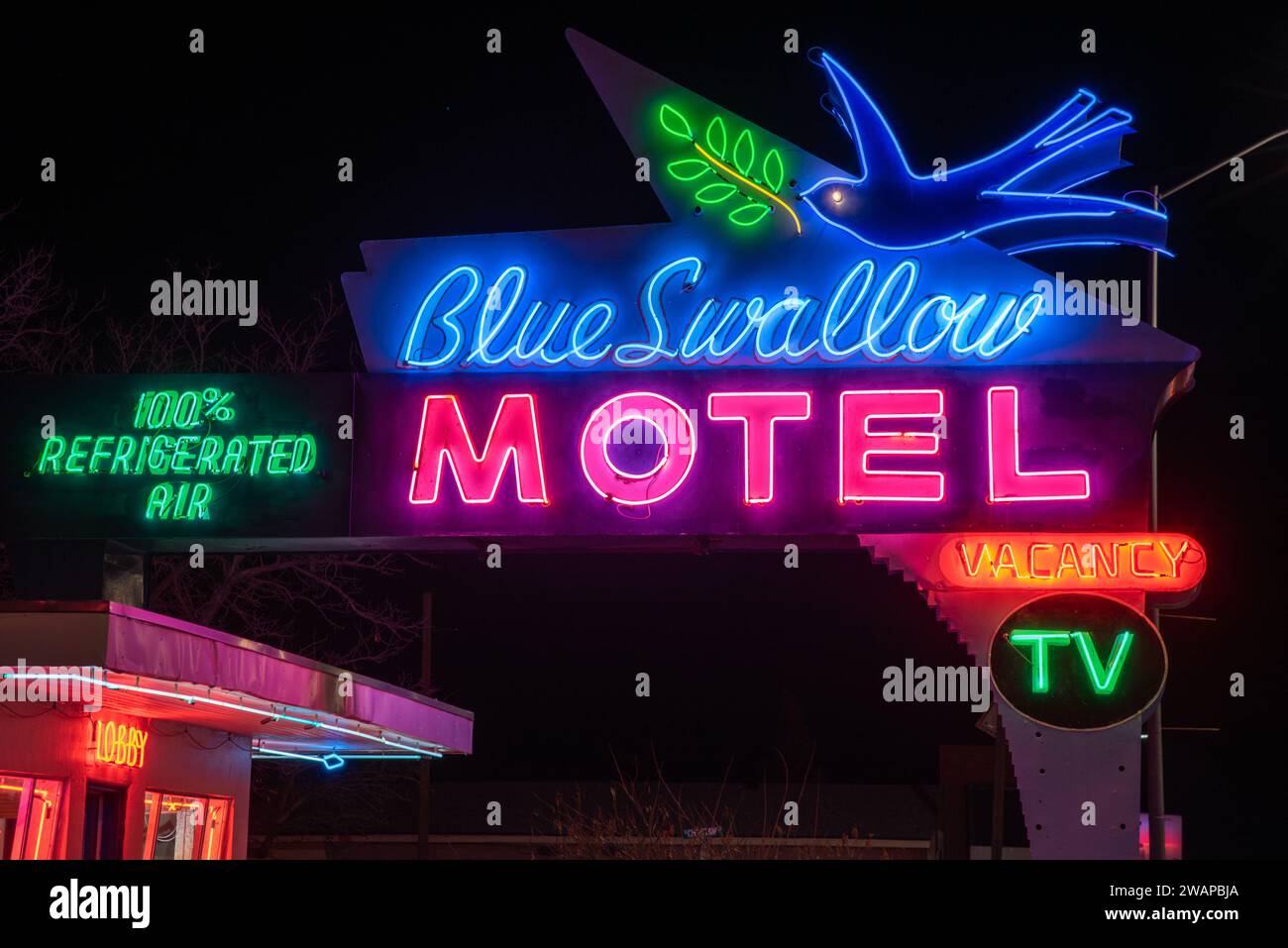 Closeup of lit colorful neon sign on Route 66 for Blue Swallow Motel, advertising vacancy and 100% refrigerated air, Tucumcari, New Mexico, USA. Stock Photo