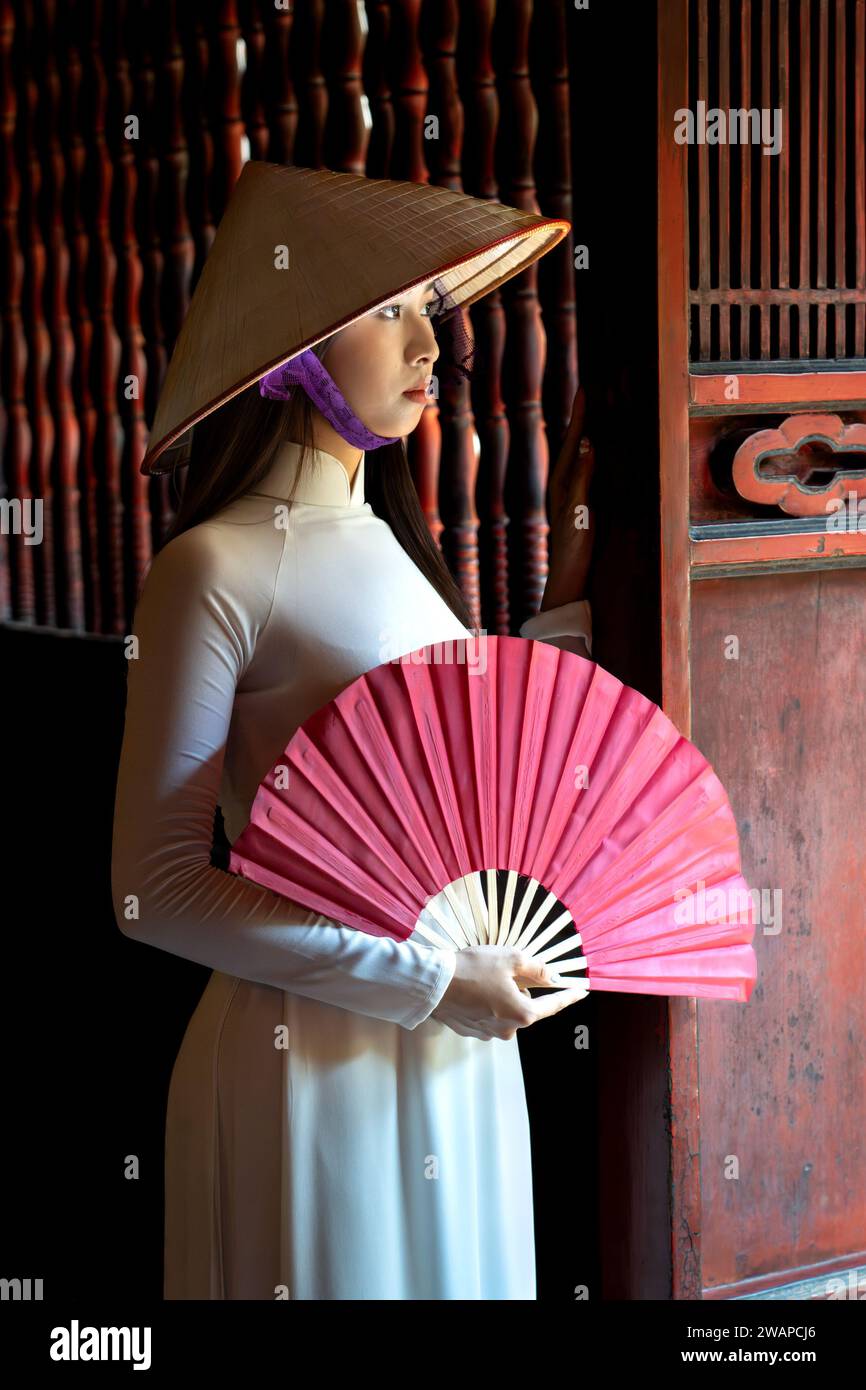 Portrait of a woman in traditional Vietnamese Ao Dai dress at the Temple of Literature, Hanoi, Vietnam Stock Photo