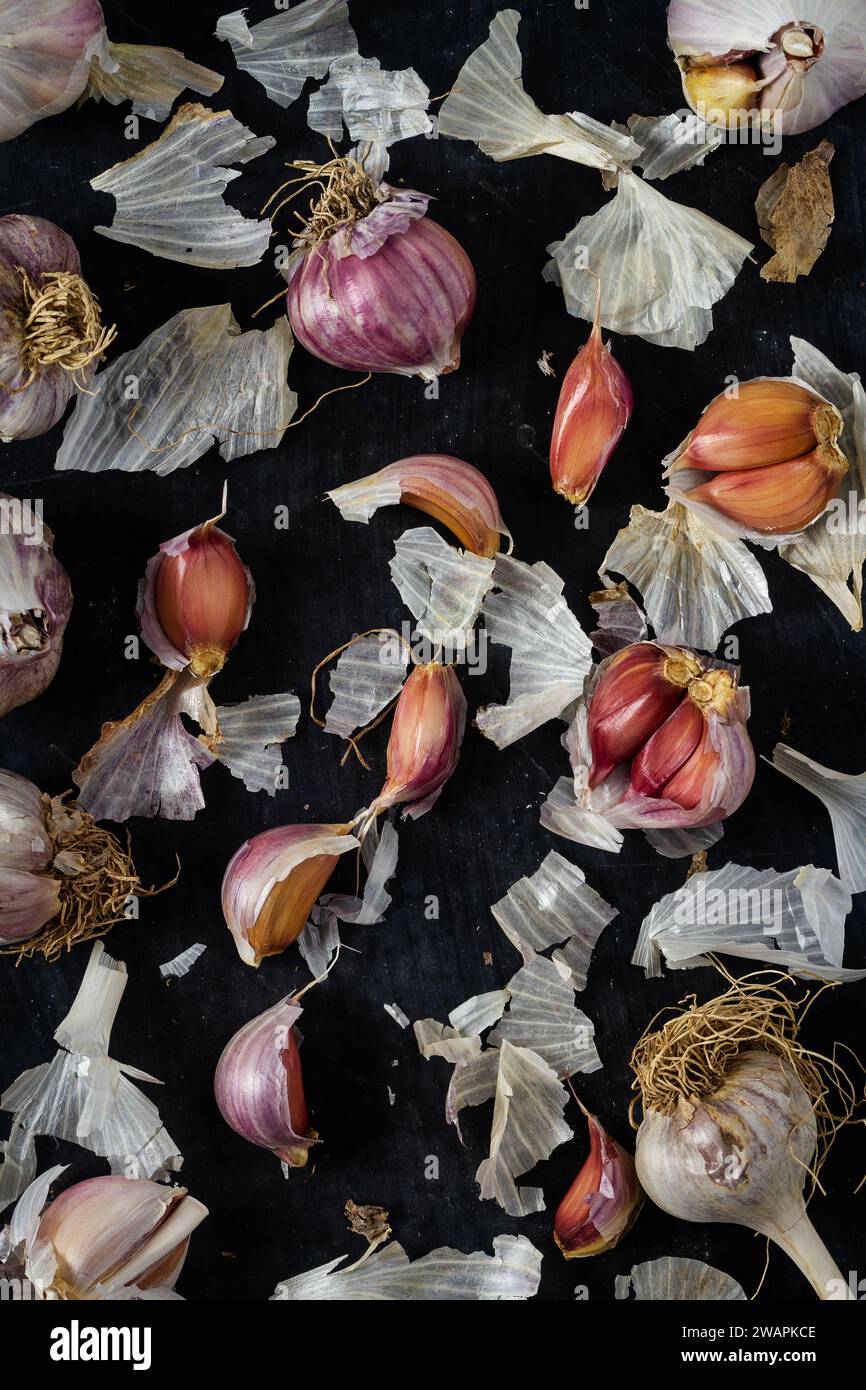 Fresh garlic bulbs and cloves grouped on black background. Flat lay ...