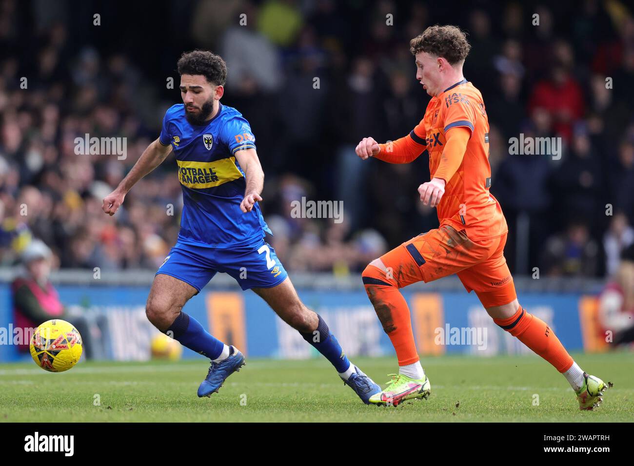 Wimbledon's Huseyin Biler (left) and Ipswich Town's Nathan Broadhead battle for the ball during the Emirates FA Cup Third Round match at the Cherry Red Records Stadium, Wimbledon. Picture date: Saturday January 6, 2024. Stock Photo