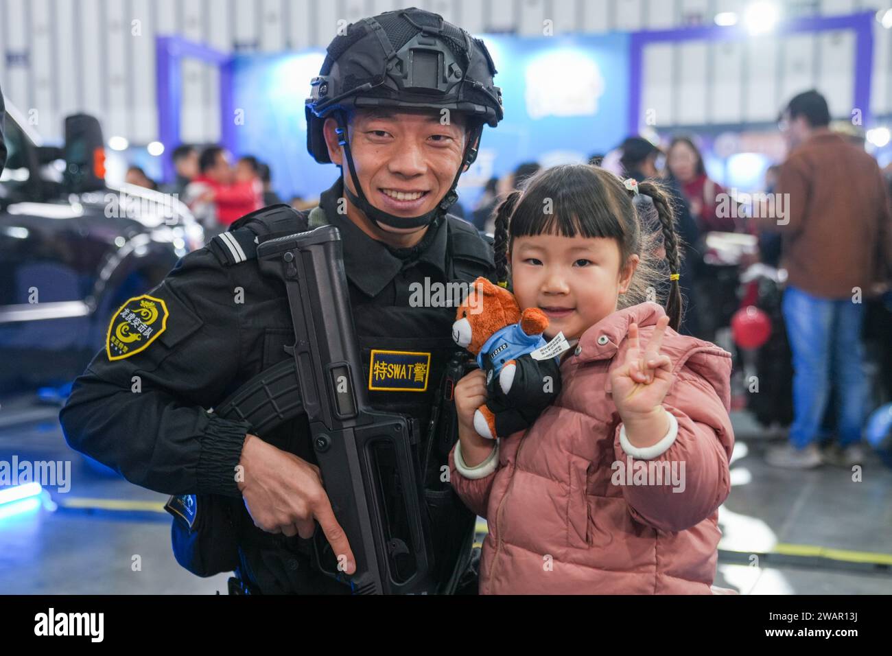 Nanjing, China's Jiangsu Province. 6th Jan, 2024. A young visitor poses with a SWAT member for a photo during a police open week event in Nanjing, east China's Jiangsu Province, Jan. 6, 2024. A five-day open week event organized by the Nanjing Municipal Public Security Bureau was initiated Saturday at Nanjing International Expo Center. With various online and offline activities, the open week aims to bring the public closer to the life and work of police officers. China will mark its fourth national police day on Jan. 10 this year. Credit: Li Bo/Xinhua/Alamy Live News Stock Photo