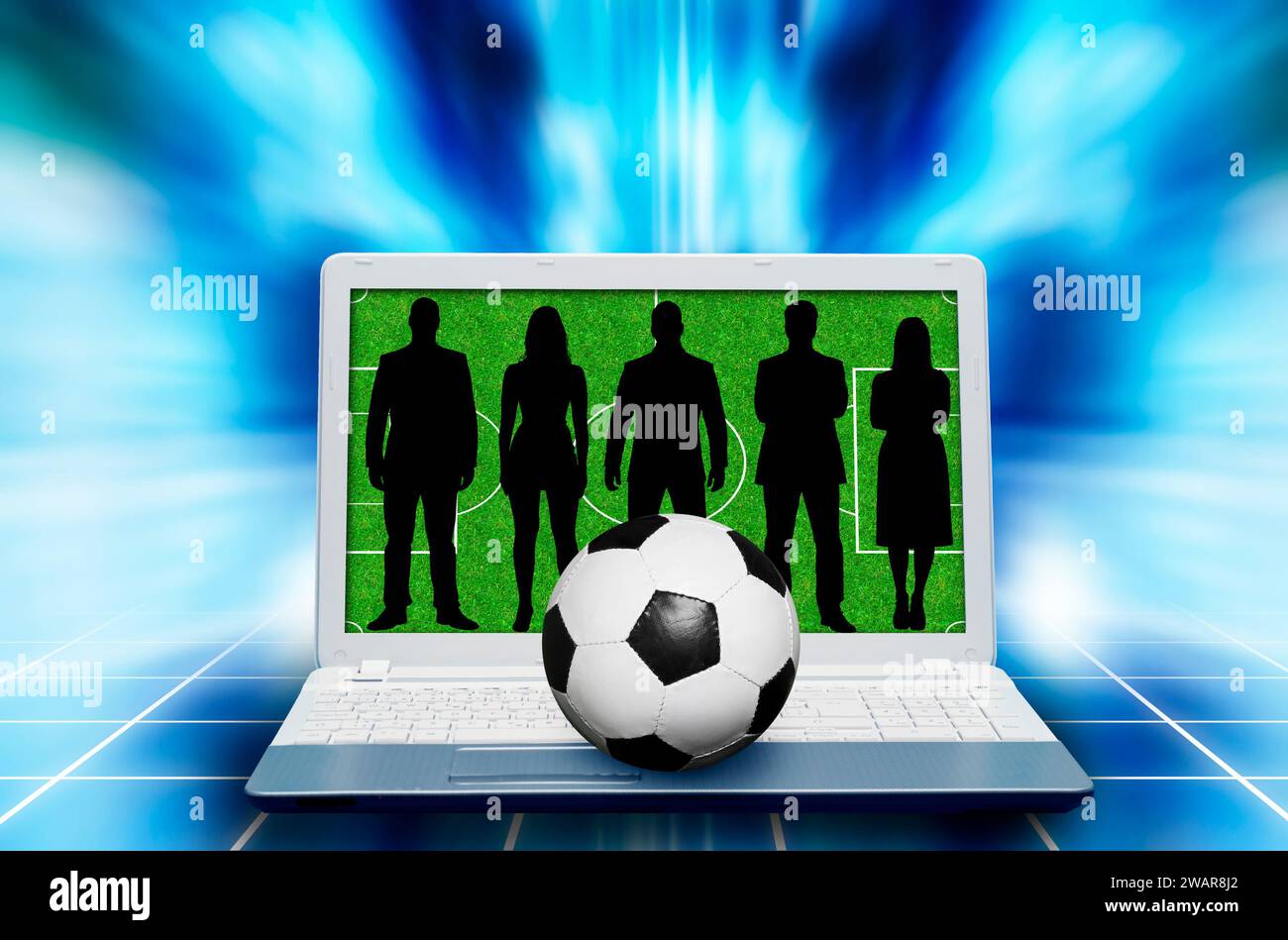 people silhouettes on laptop screen with a soccer pitch and a soccer ball Stock Photo