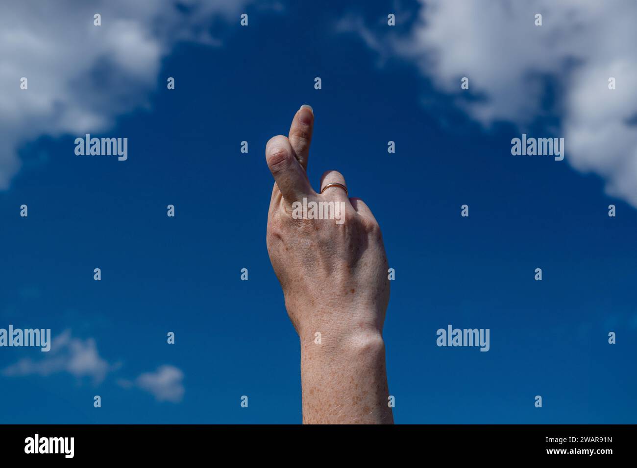 girls hand shows finger cross and symbol on white background Stock Photo