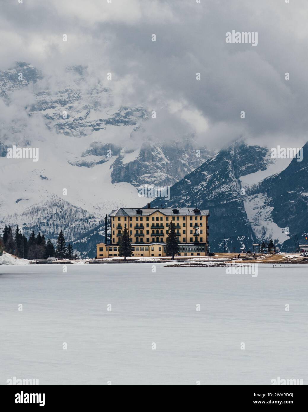 A majestic high-rise building is nestled against a snowy mountain ...
